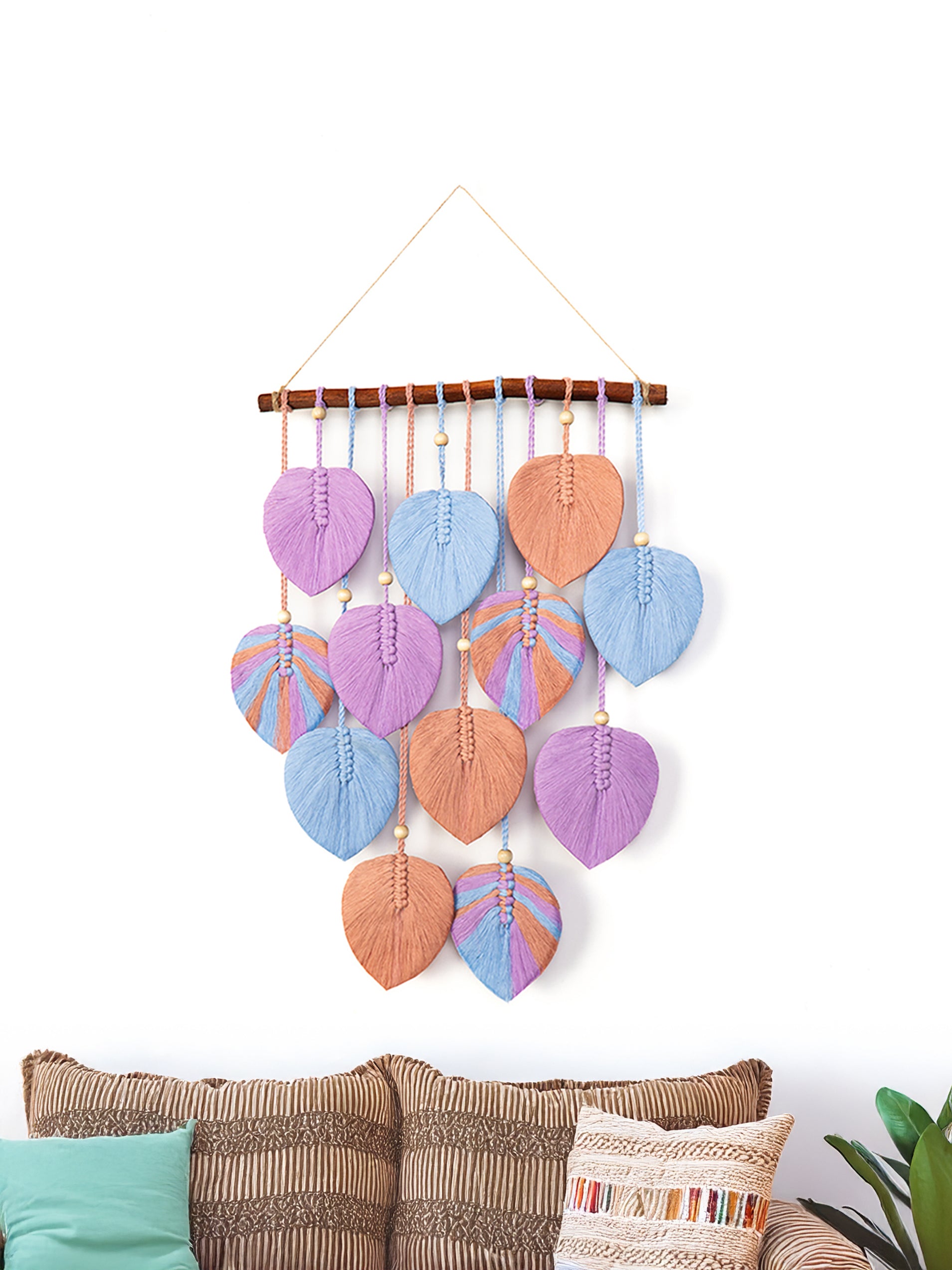 Colorful leaf-shaped wall hanging with a wooden base on a white background