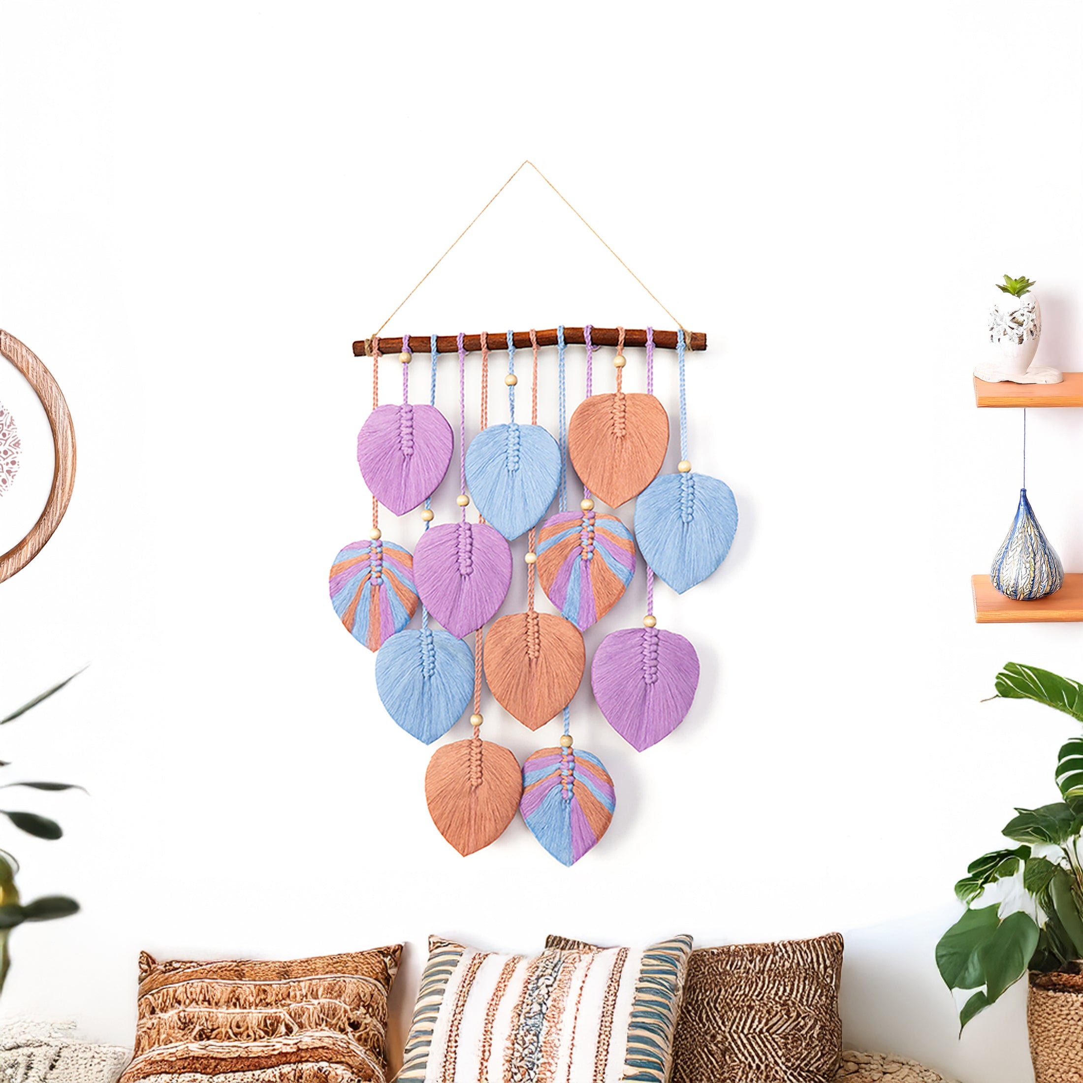 Decorative wall hanging with colorful leaf-shaped beads on a white wall.
