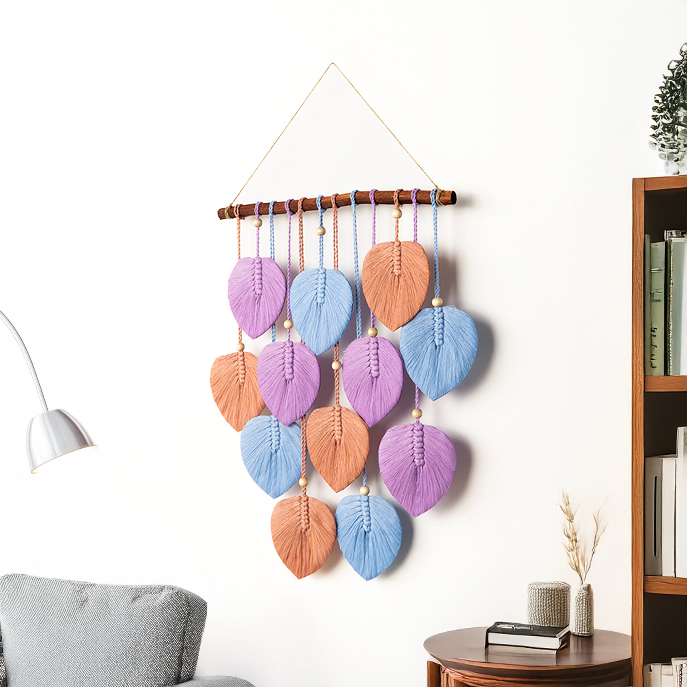 Decorative wall hanging with colorful leaf-shaped beads in a living room setting.