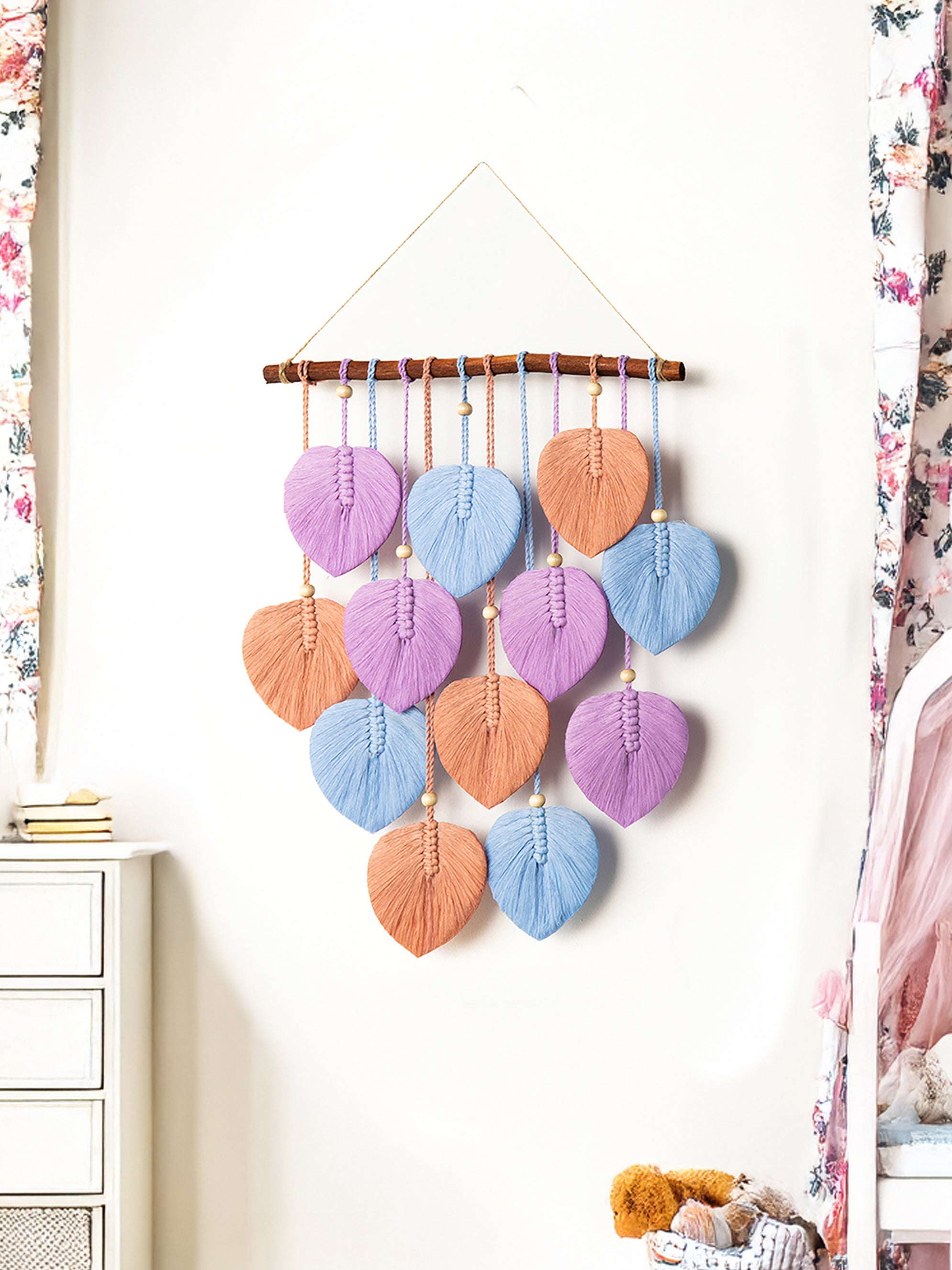 Decorative wall hanging with colorful leaf-shaped elements in a room setting.