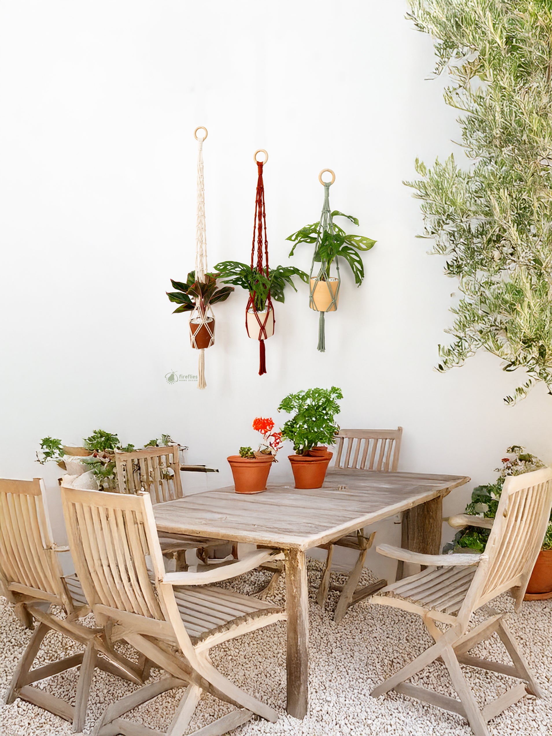 Outdoor patio with wooden table and chairs, potted plants, and hanging decorations.