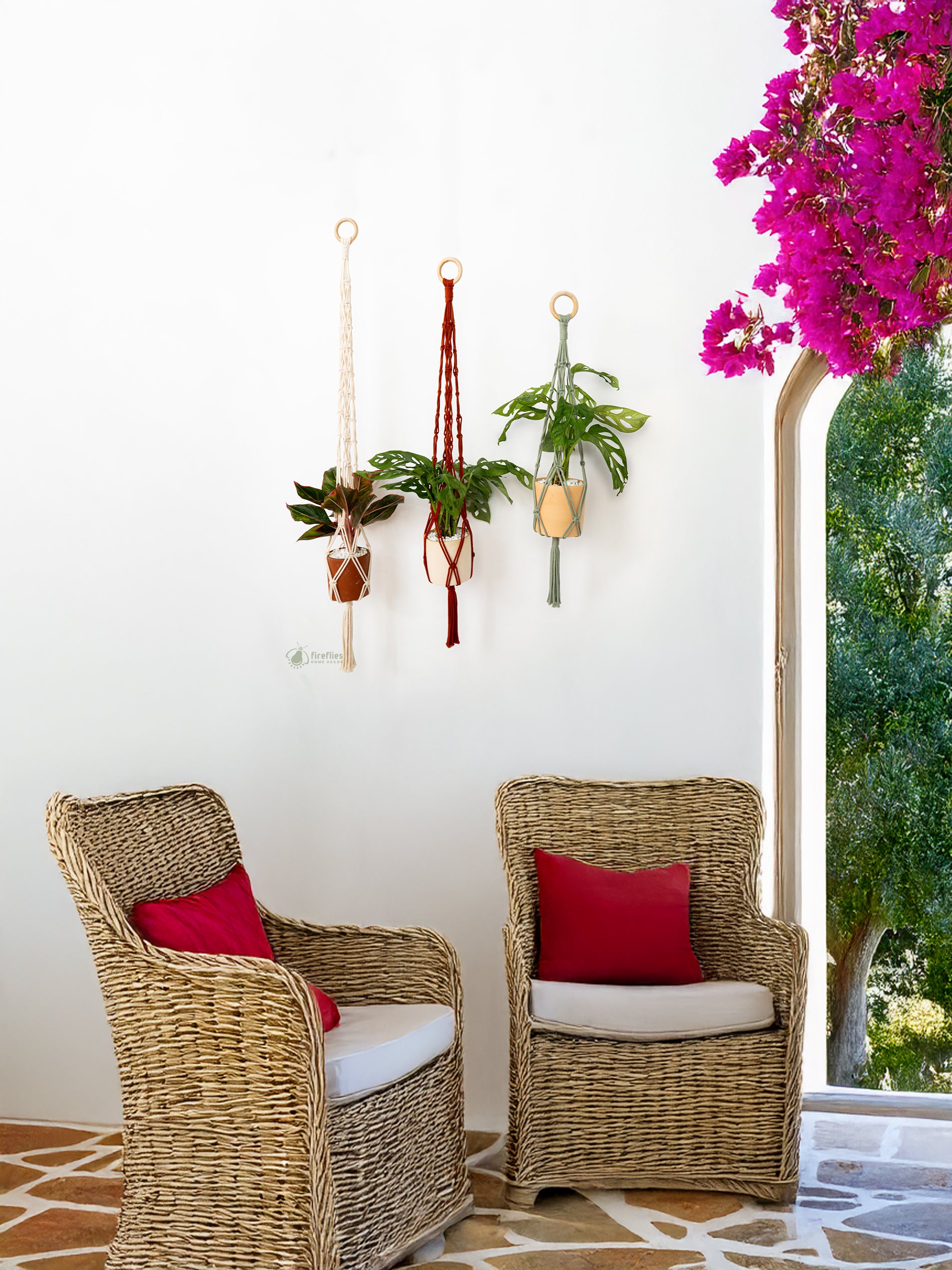 Two wicker chairs with red cushions in a room with plants and a window.
