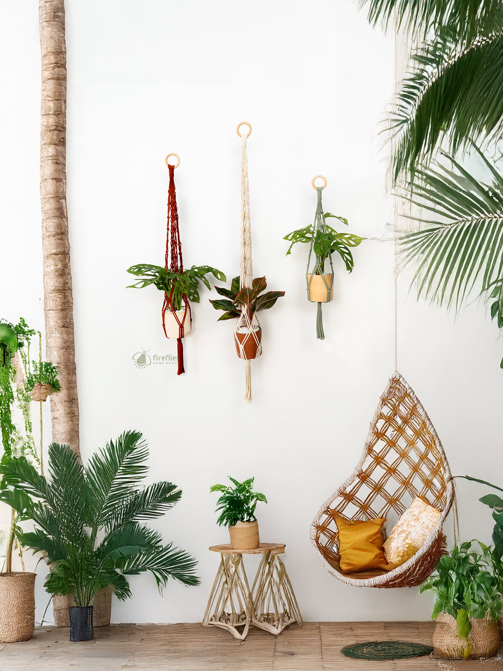 Cozy indoor setting with a hanging wicker chair, plants, and a small table against a white wall.