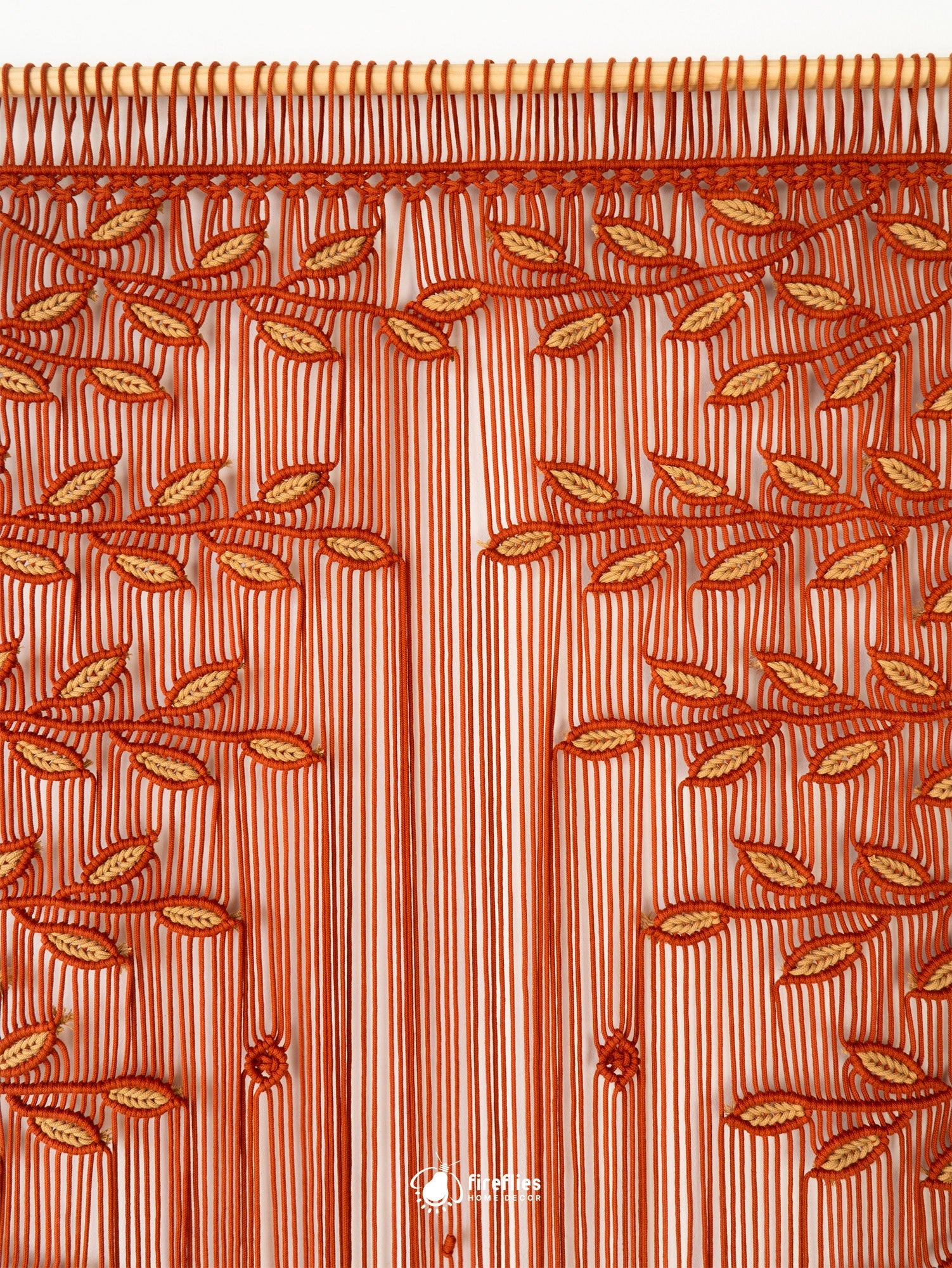 A brown and beige striped curtain panel with an embroidered tree branch and leaf pattern across the top, vertical fringe, and small tassel details.