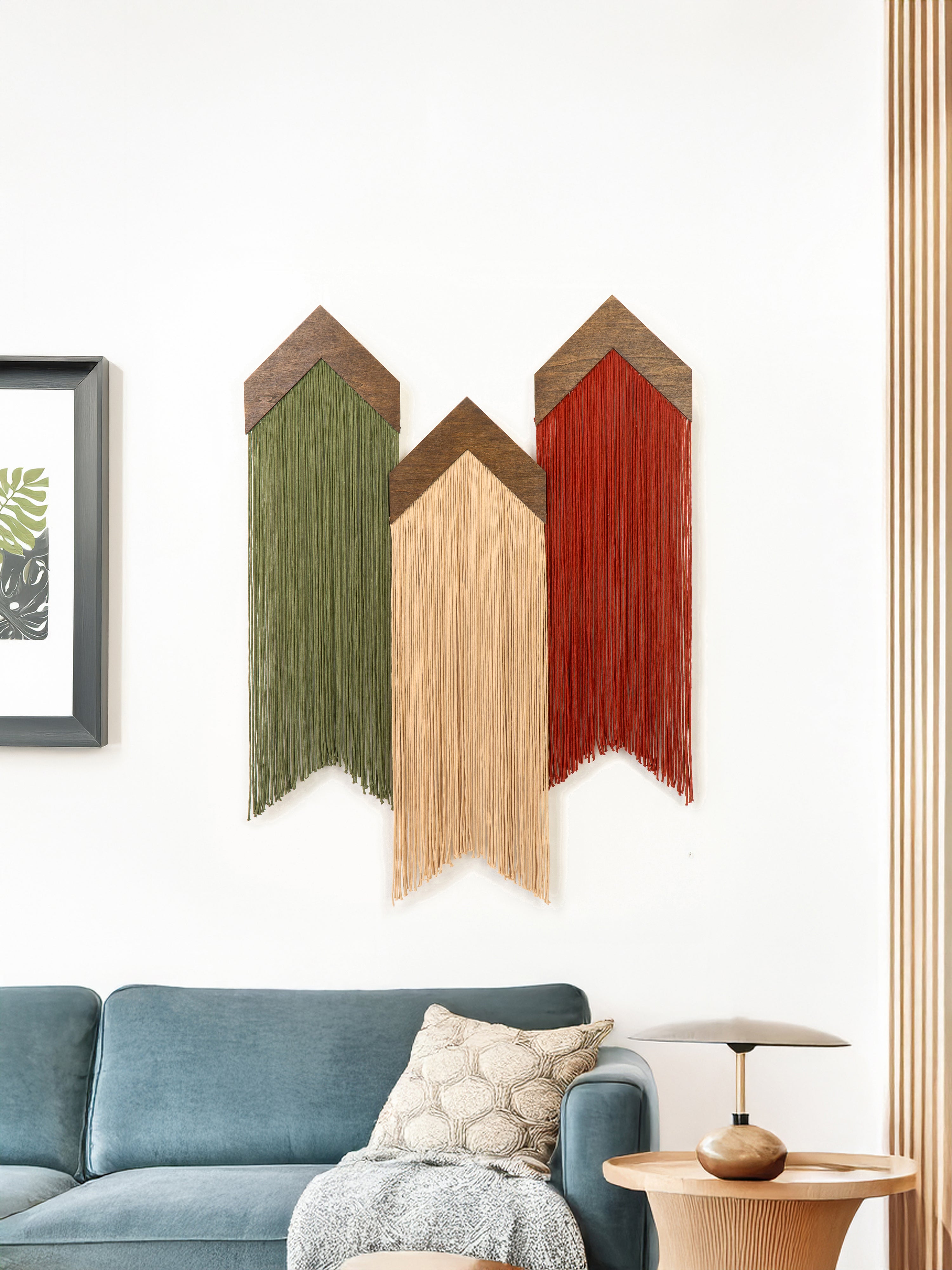 Decorative wall art with wooden panels in green, brown, and red above a blue sofa.