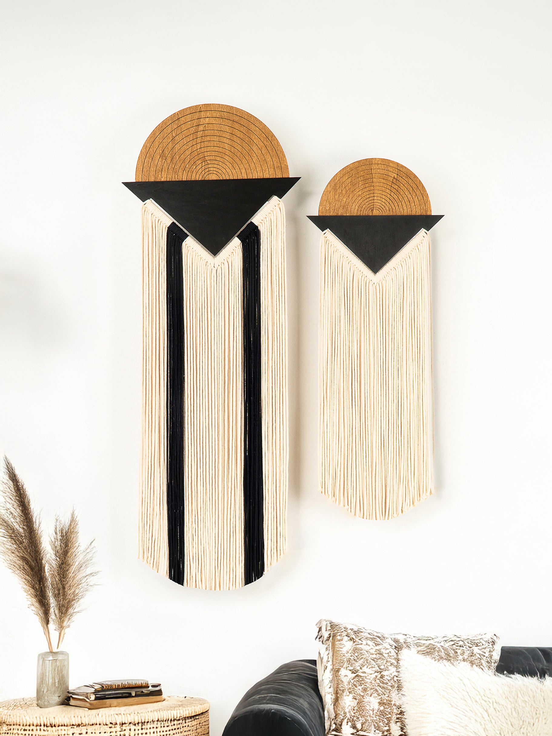 Two wall art pieces with geometric designs on a white wall.