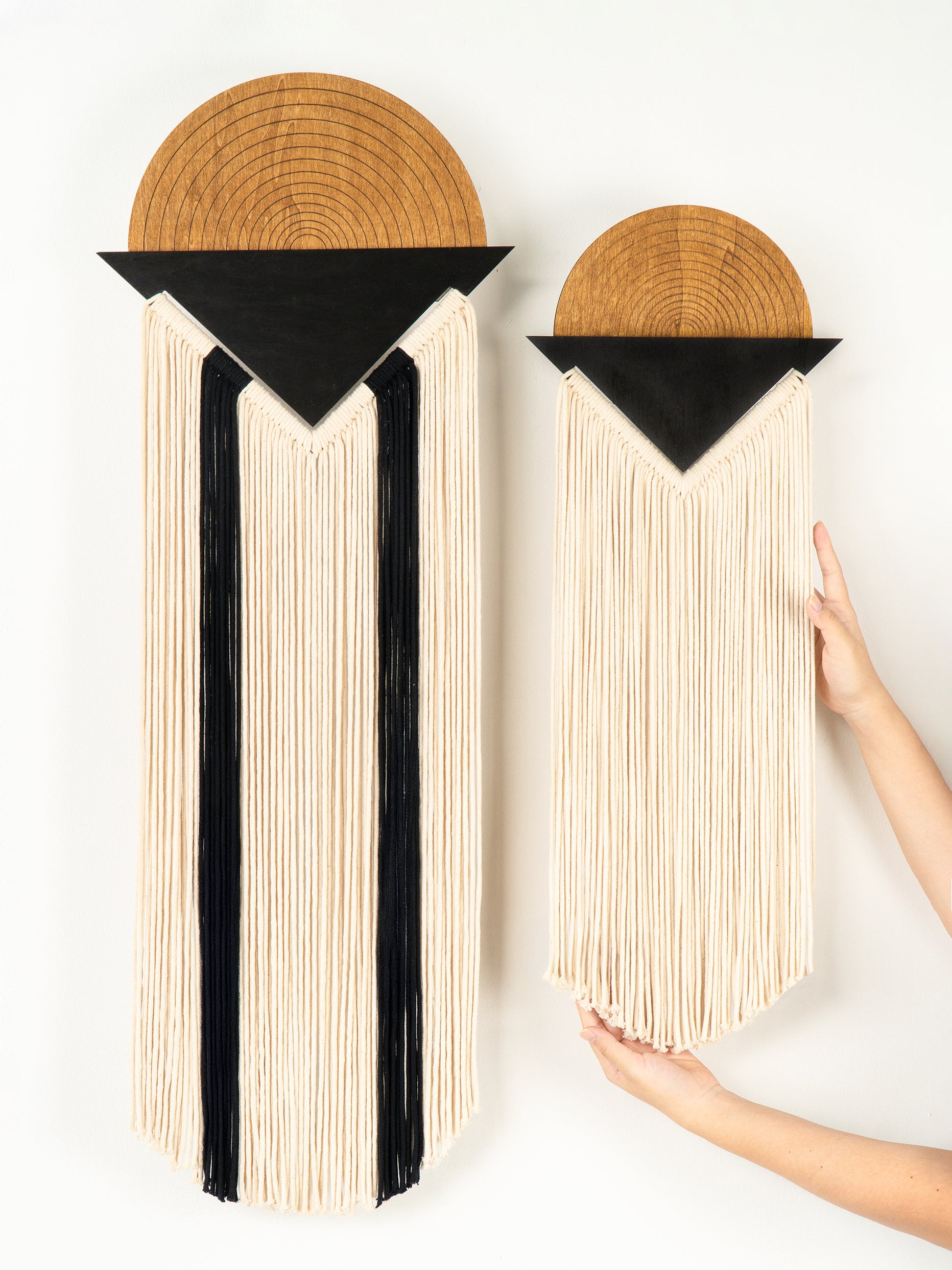 Two book-shaped wall art pieces with wooden tops and black and white interiors on a white background.