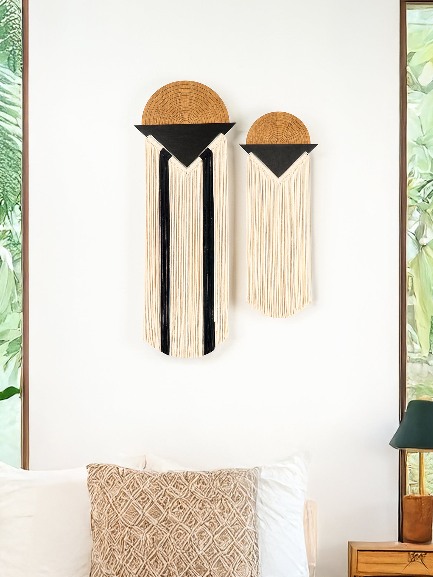 Two wall hangings with geometric designs on a white wall.