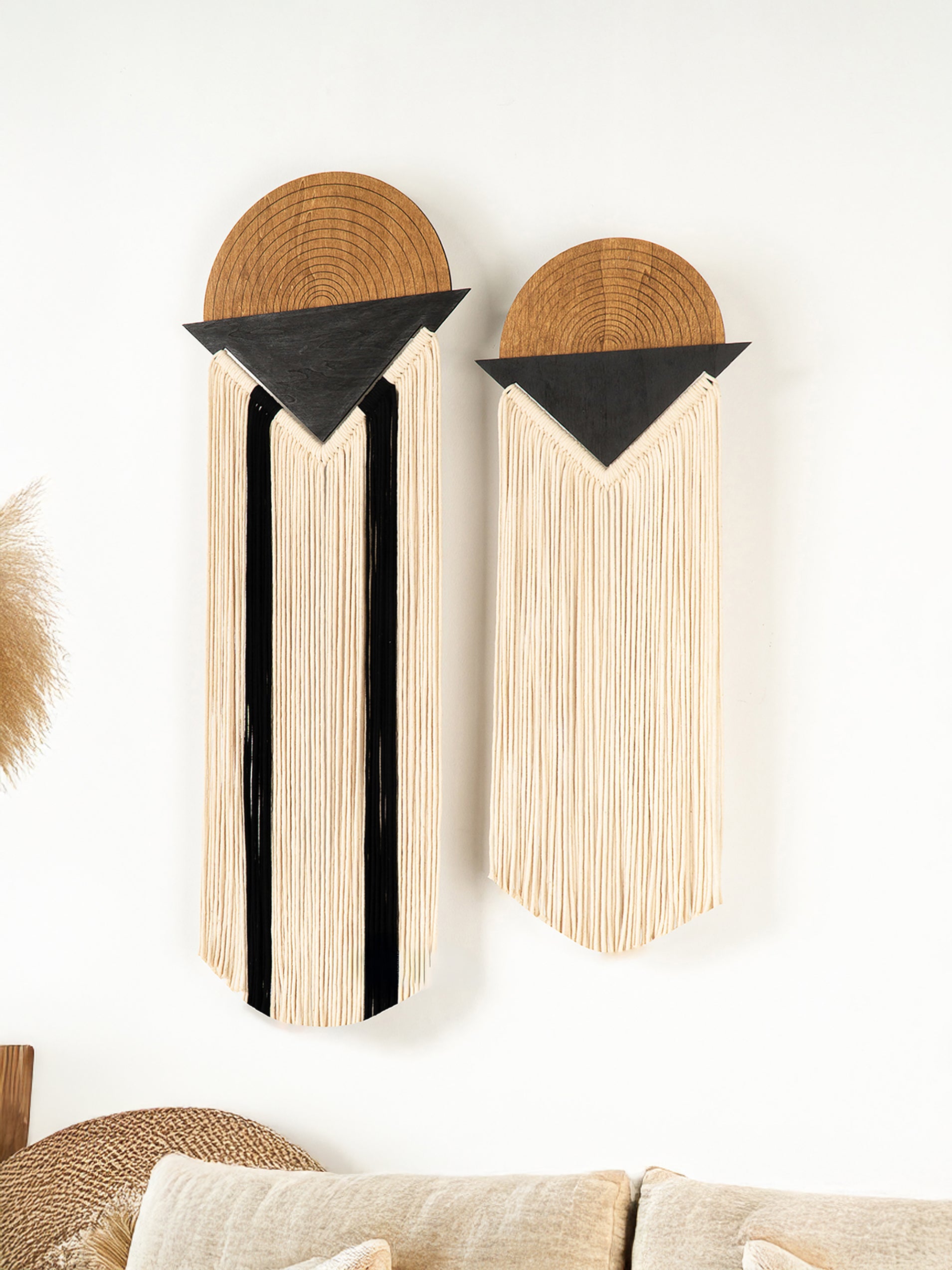 Two wooden wall art pieces with geometric designs on a white wall.