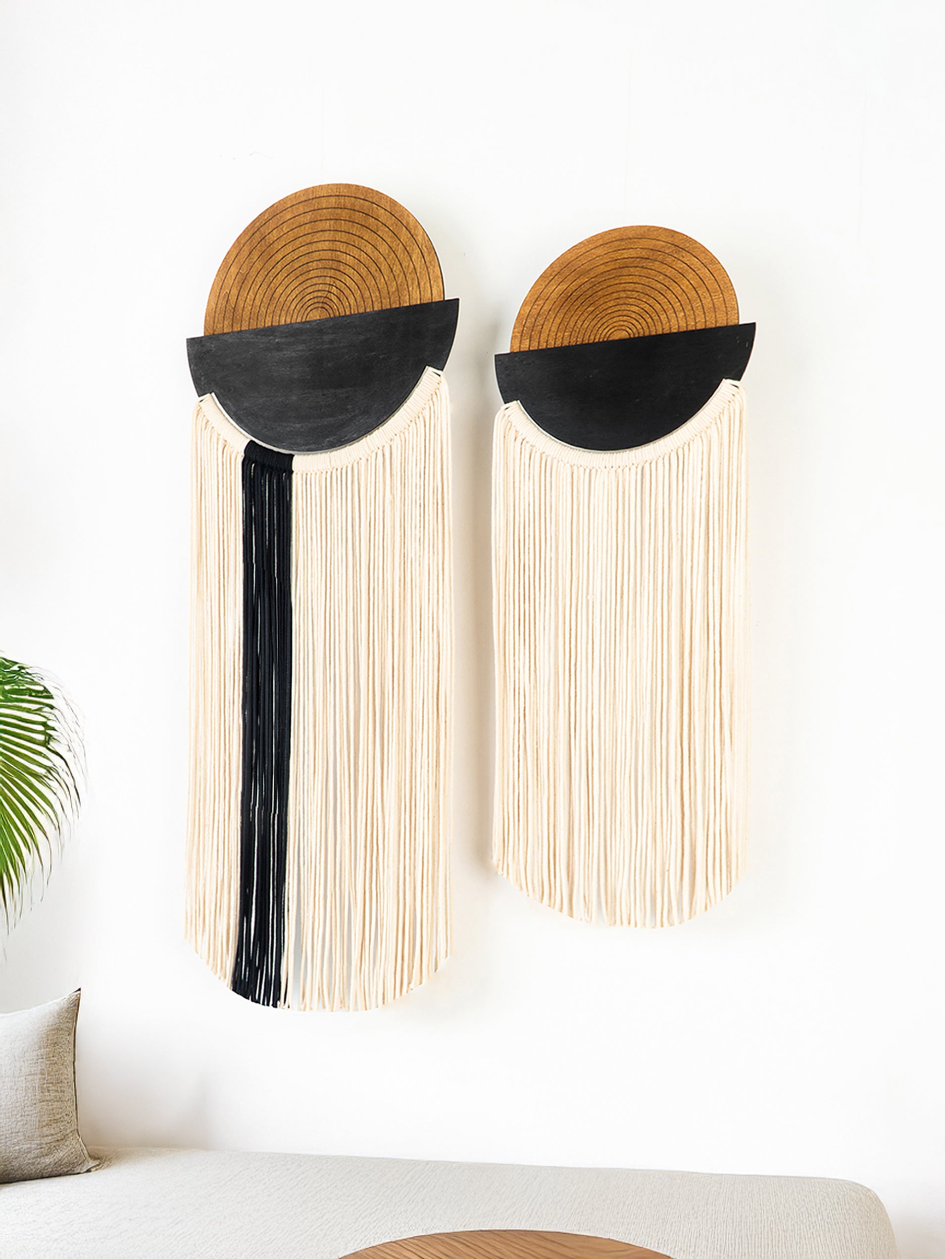 Decorative wall art with geometric design on a white wall above a sofa.