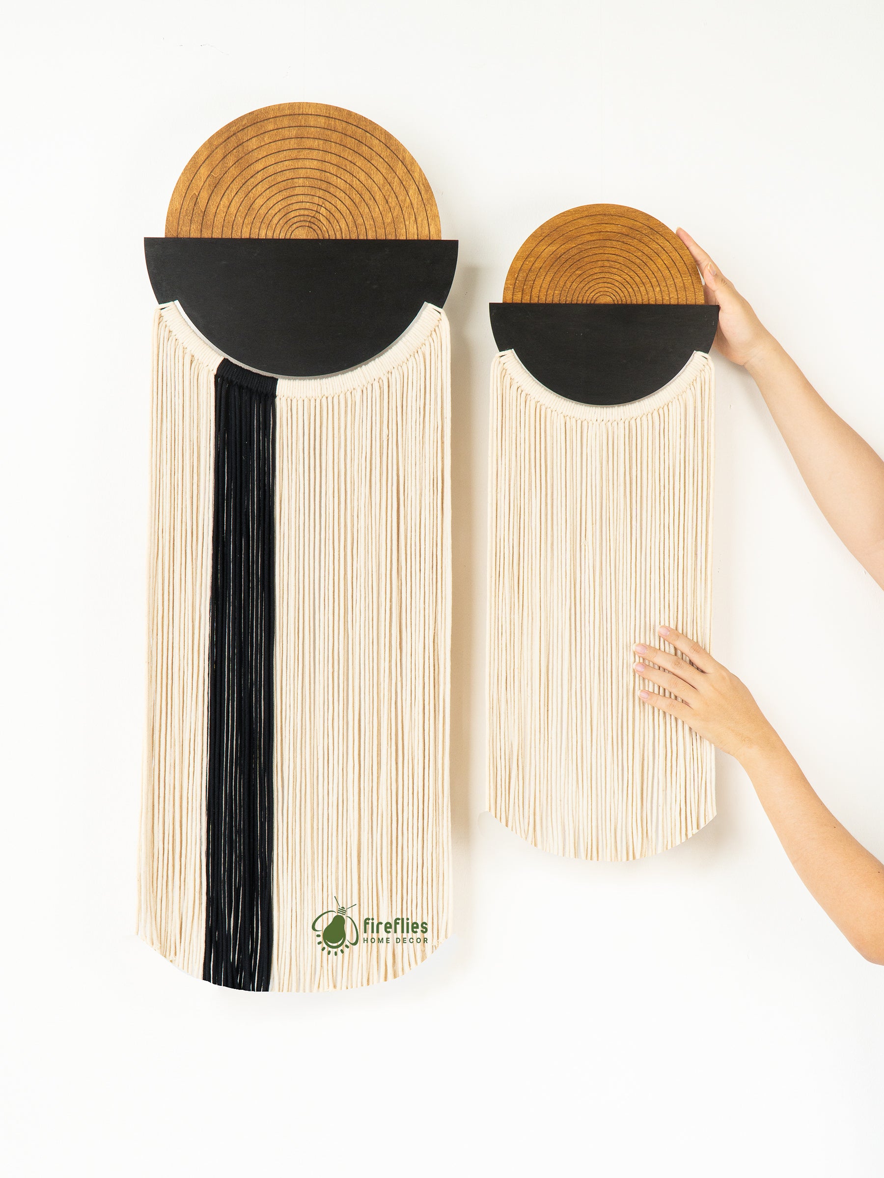 Two wall-mounted woven mats with a black central strip, held by a hand on a white background.