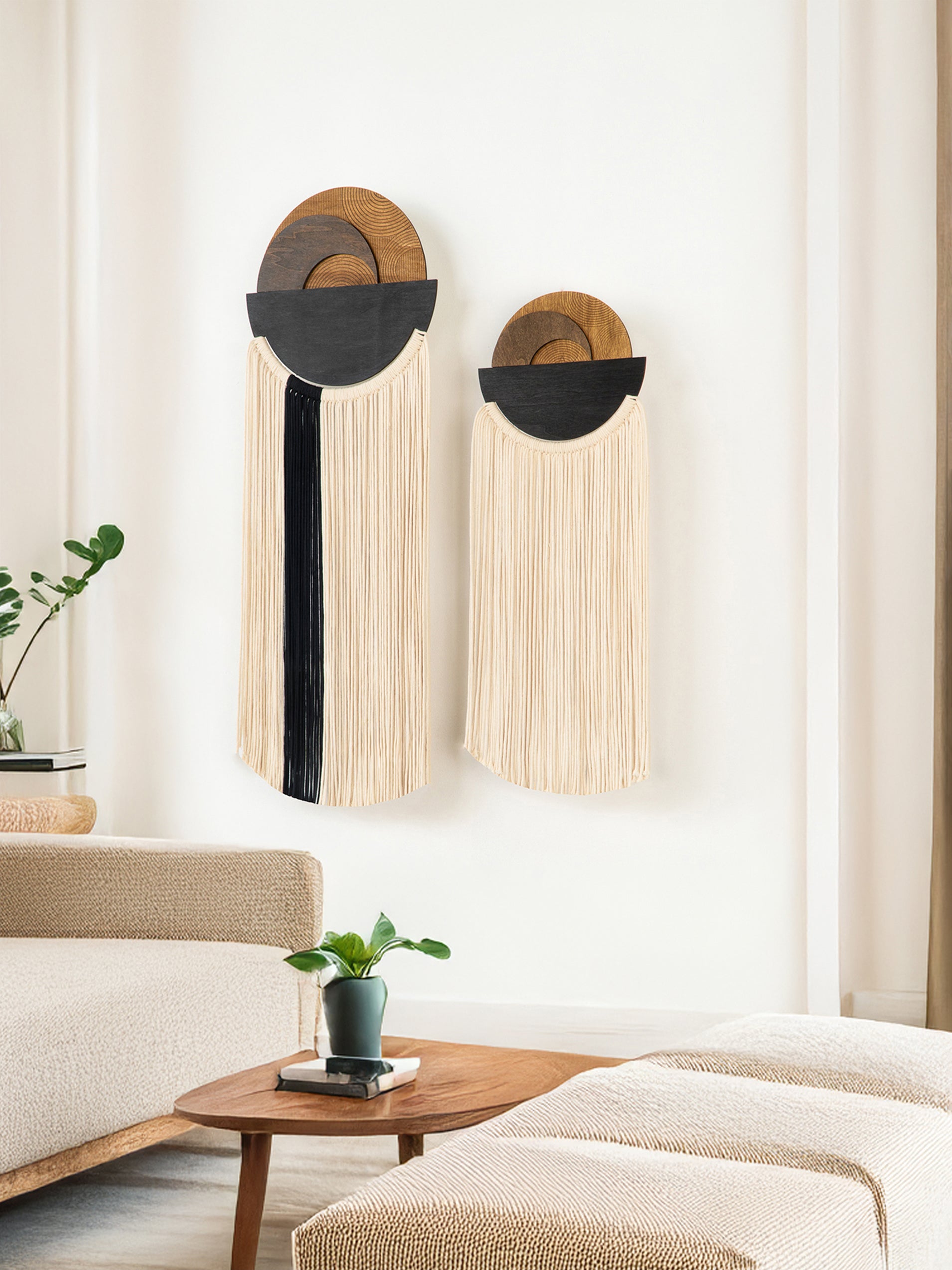 Woven wall art pieces with black and gold accents on a white wall above a beige sofa.