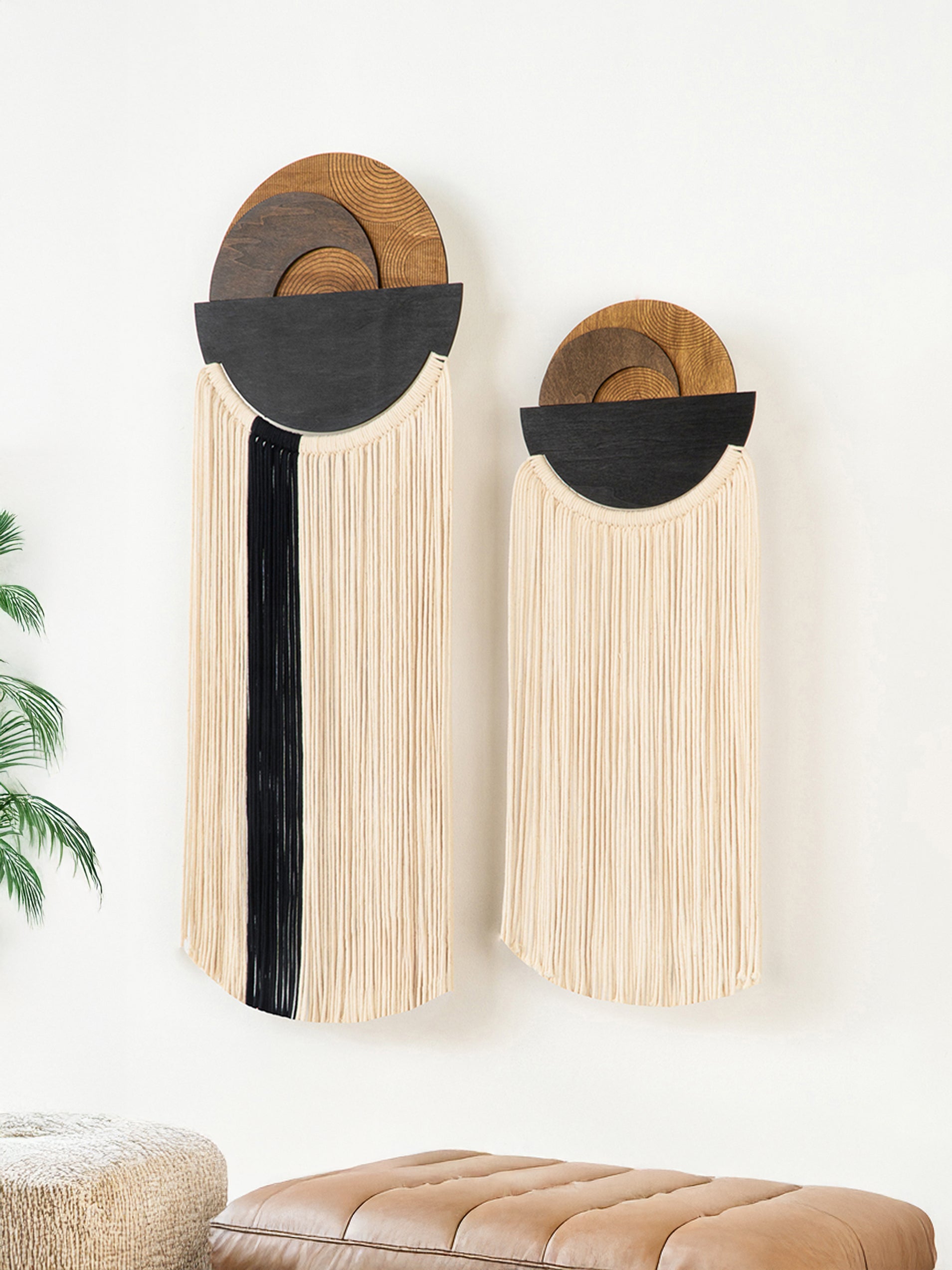Two wall-mounted decorative pieces with wooden and black elements on a white wall.