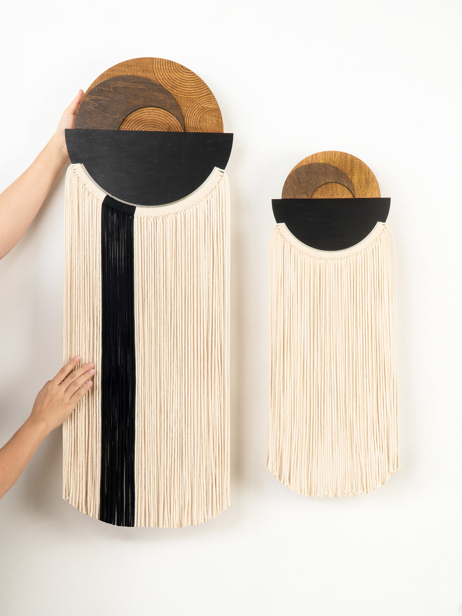 Two wall-mounted woven baskets with black accents on a white background