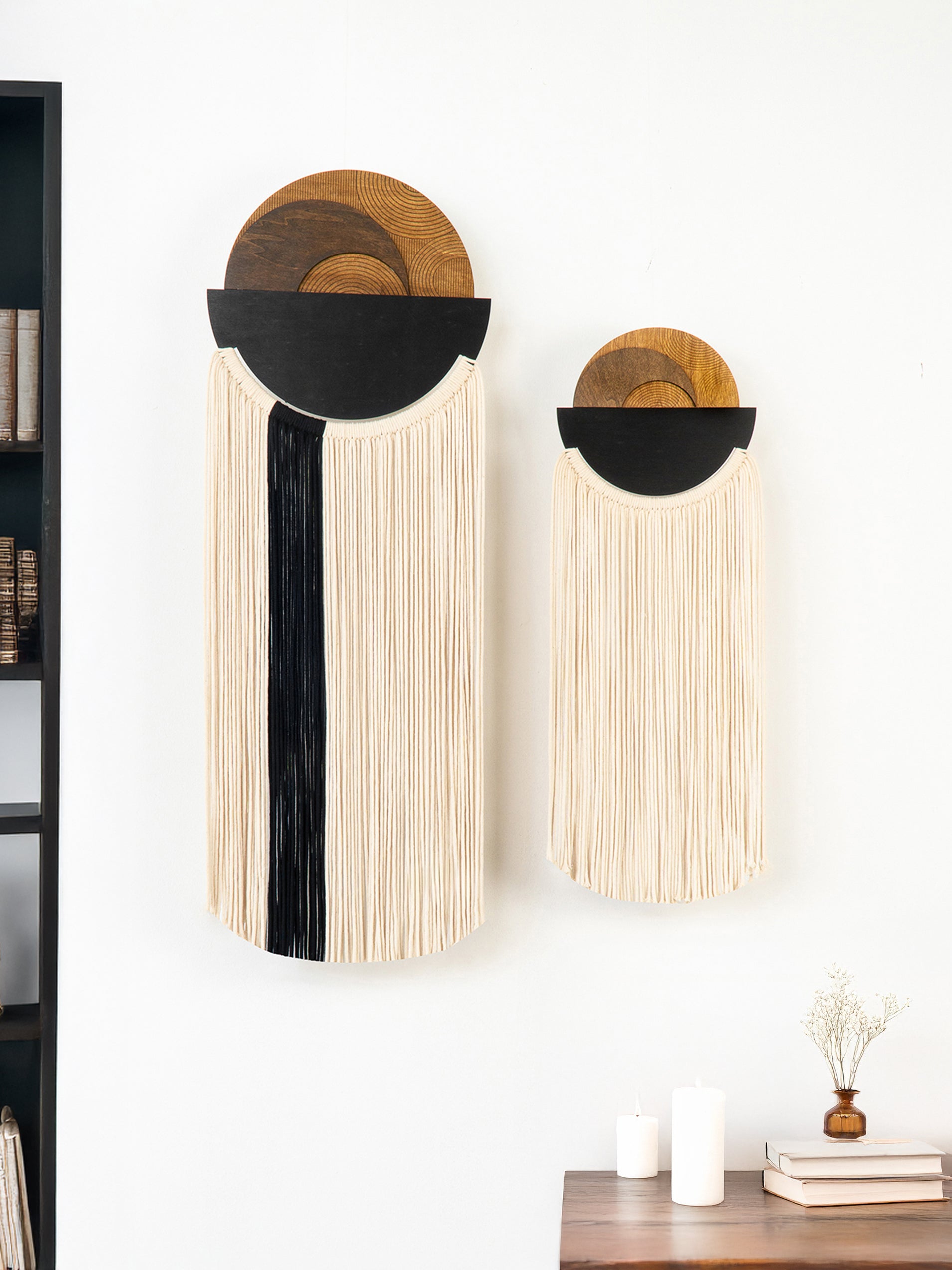 Two wall-mounted decorative items with circular designs on a white wall.