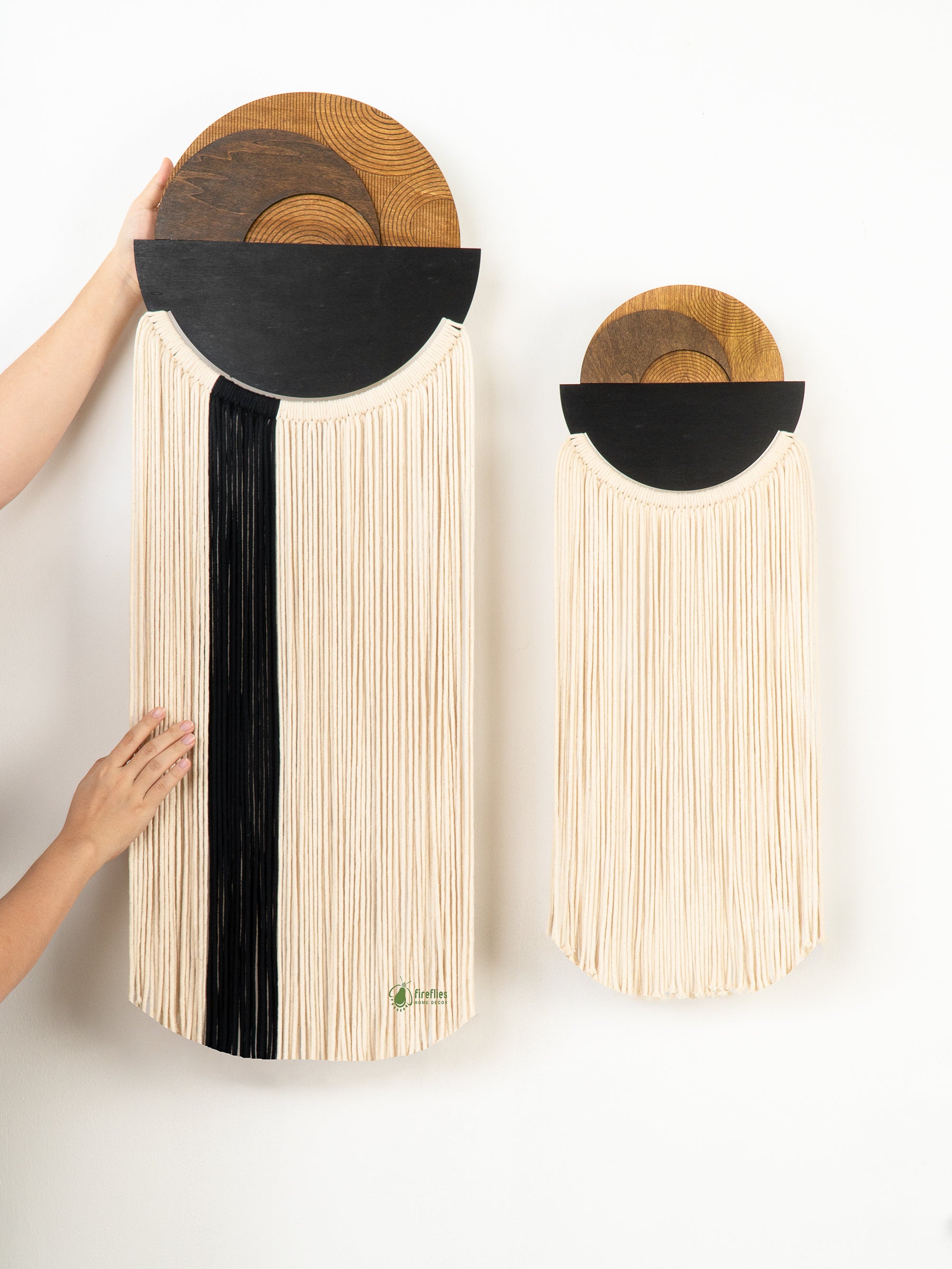 Two wooden boards with black and natural finishes held against a white background