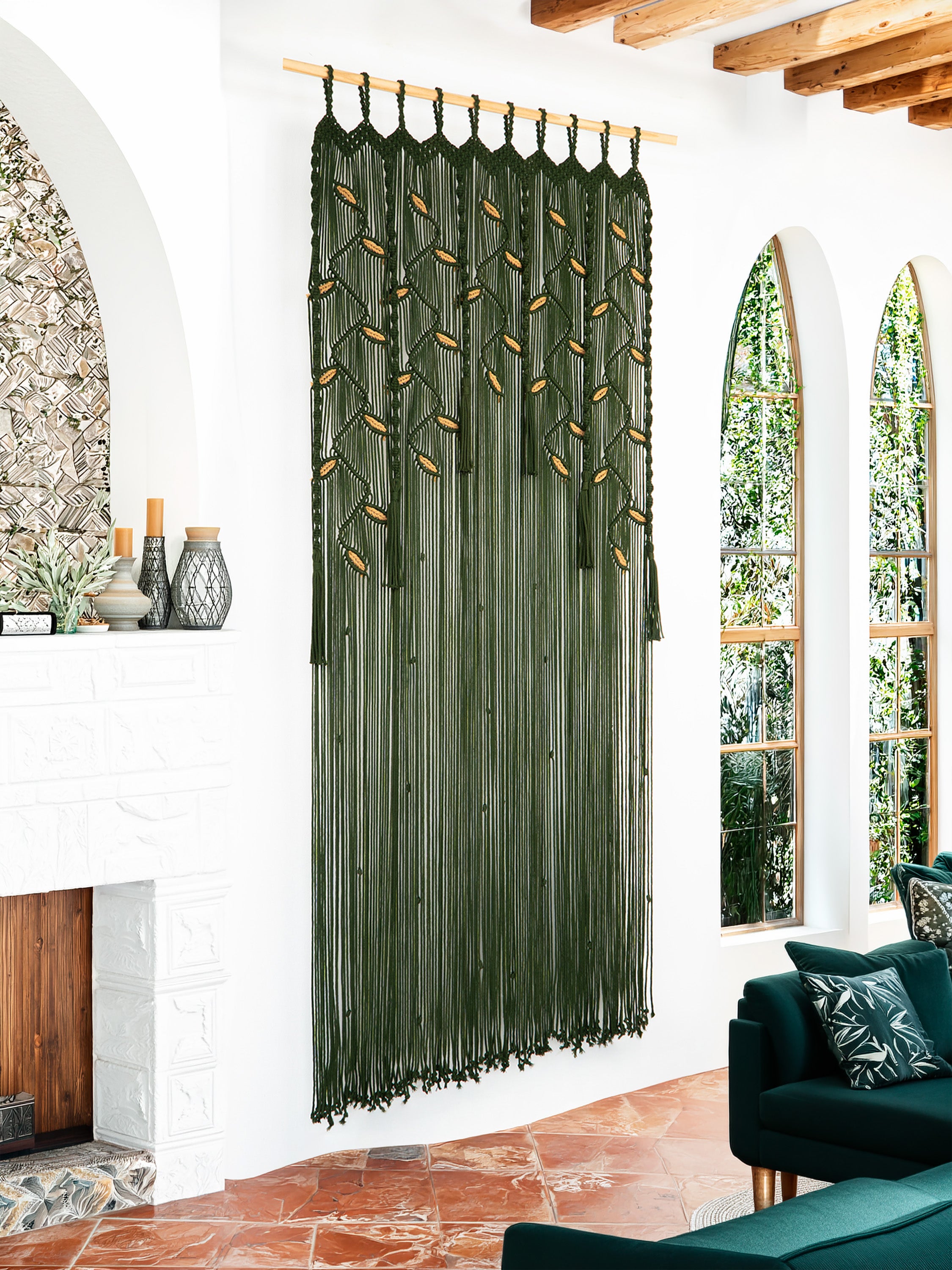 Green macrame curtain in a living room with a fireplace and windows.