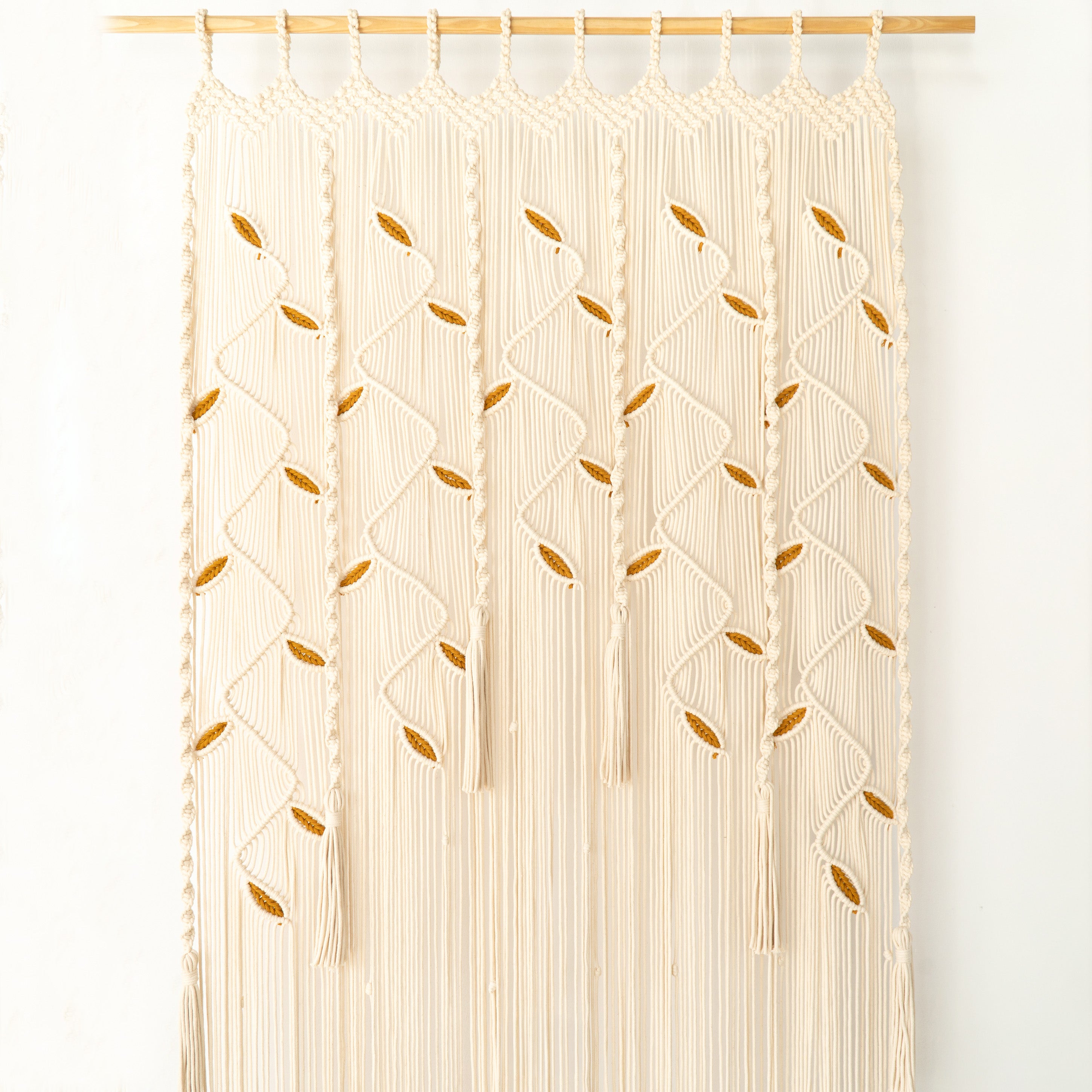 Beige macrame curtain with geometric pattern on a white background