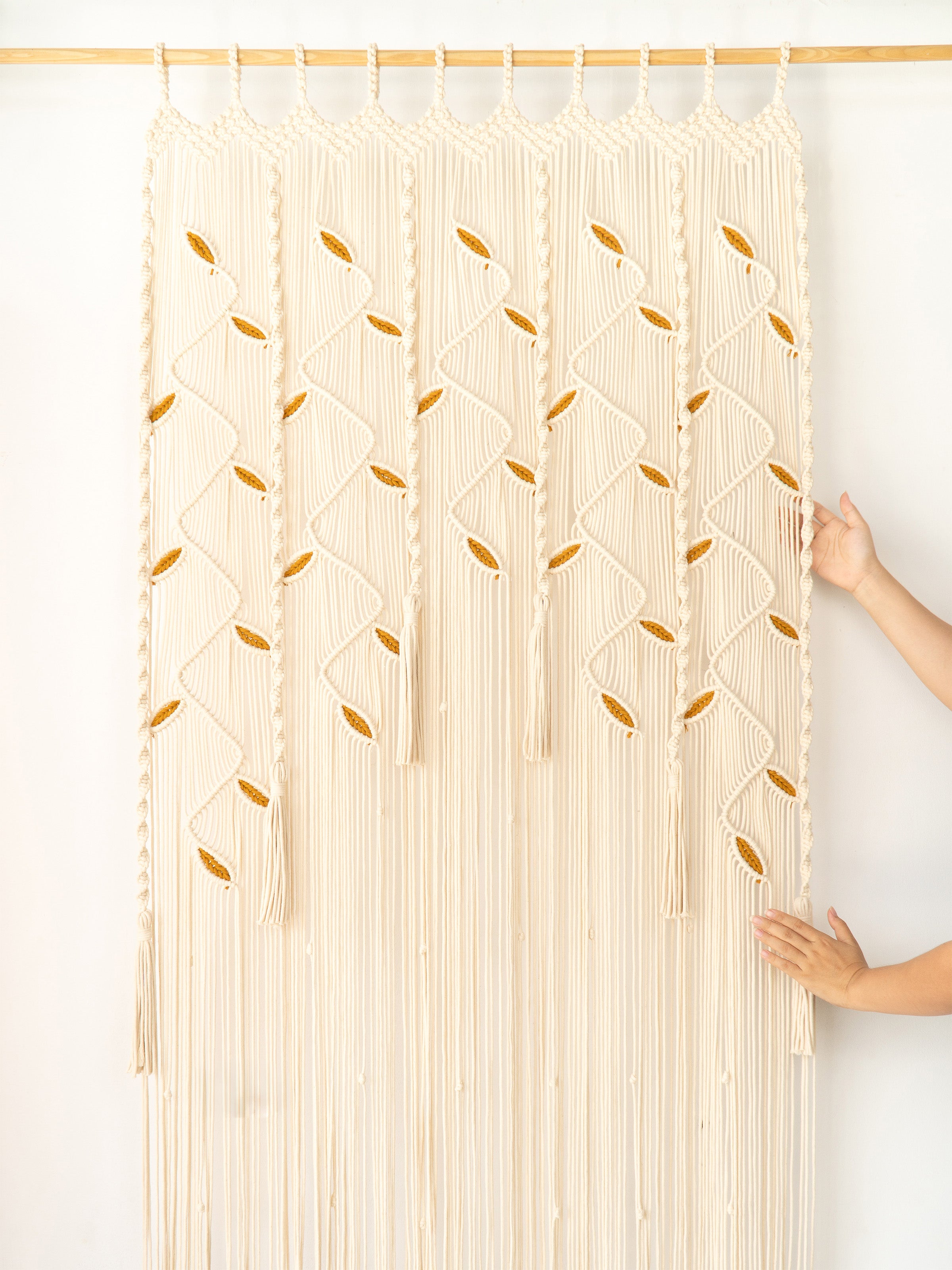 Macrame wall hanging with geometric pattern on a white wall
