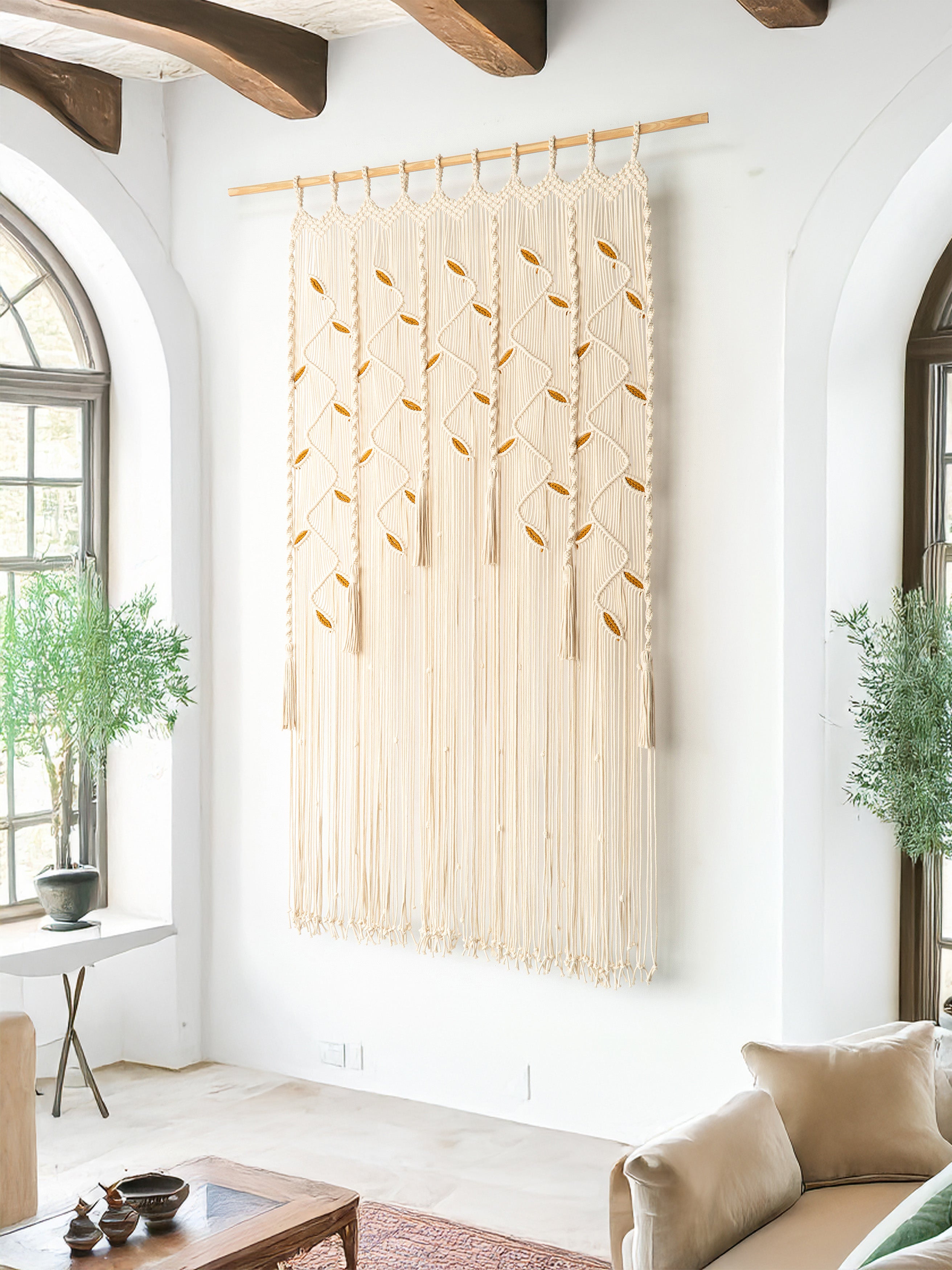 Woven wall art hanging in a living room with white walls and wooden beams.