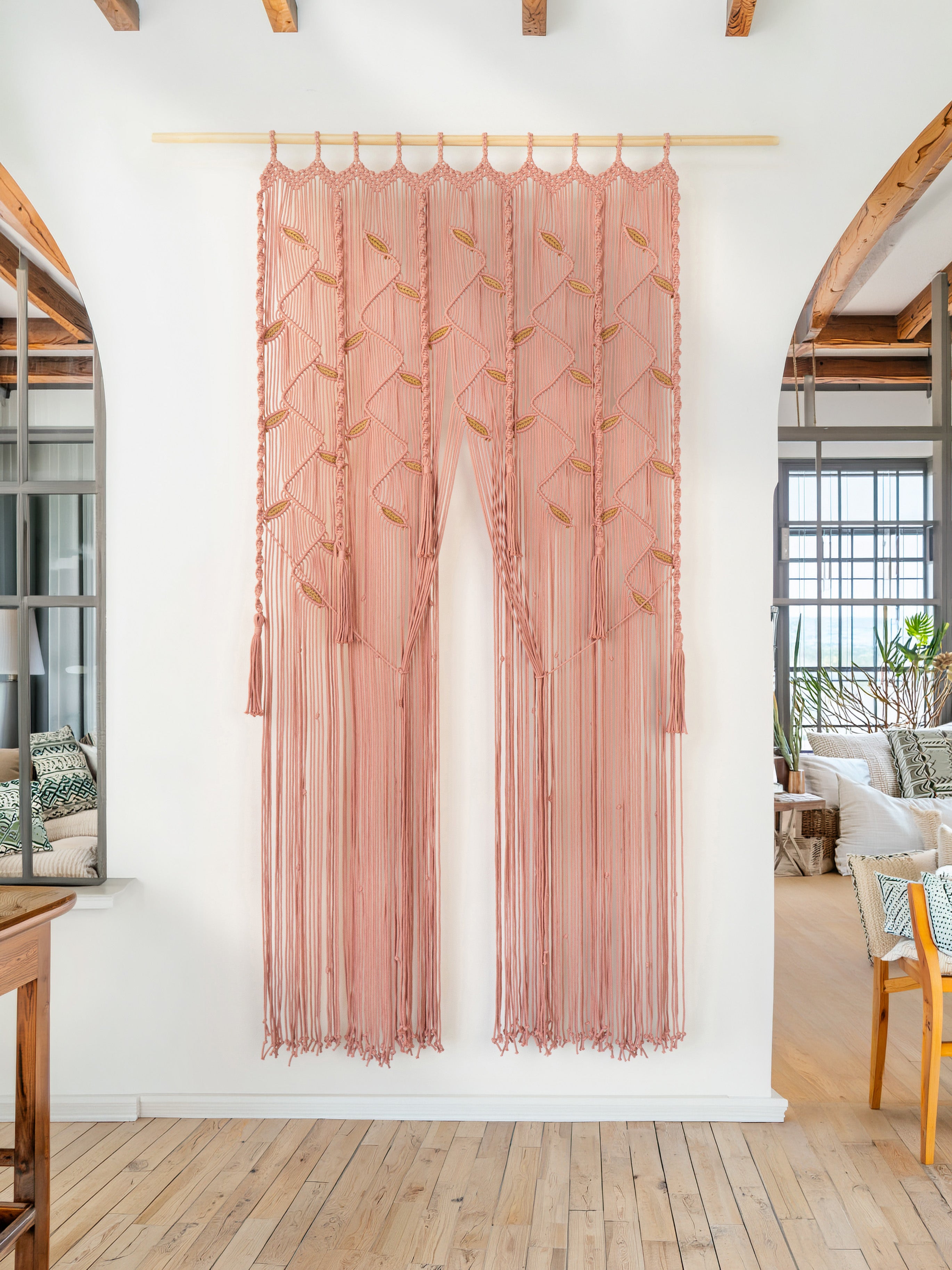 Pink sheer curtain hanging in a room with wooden floor and white walls