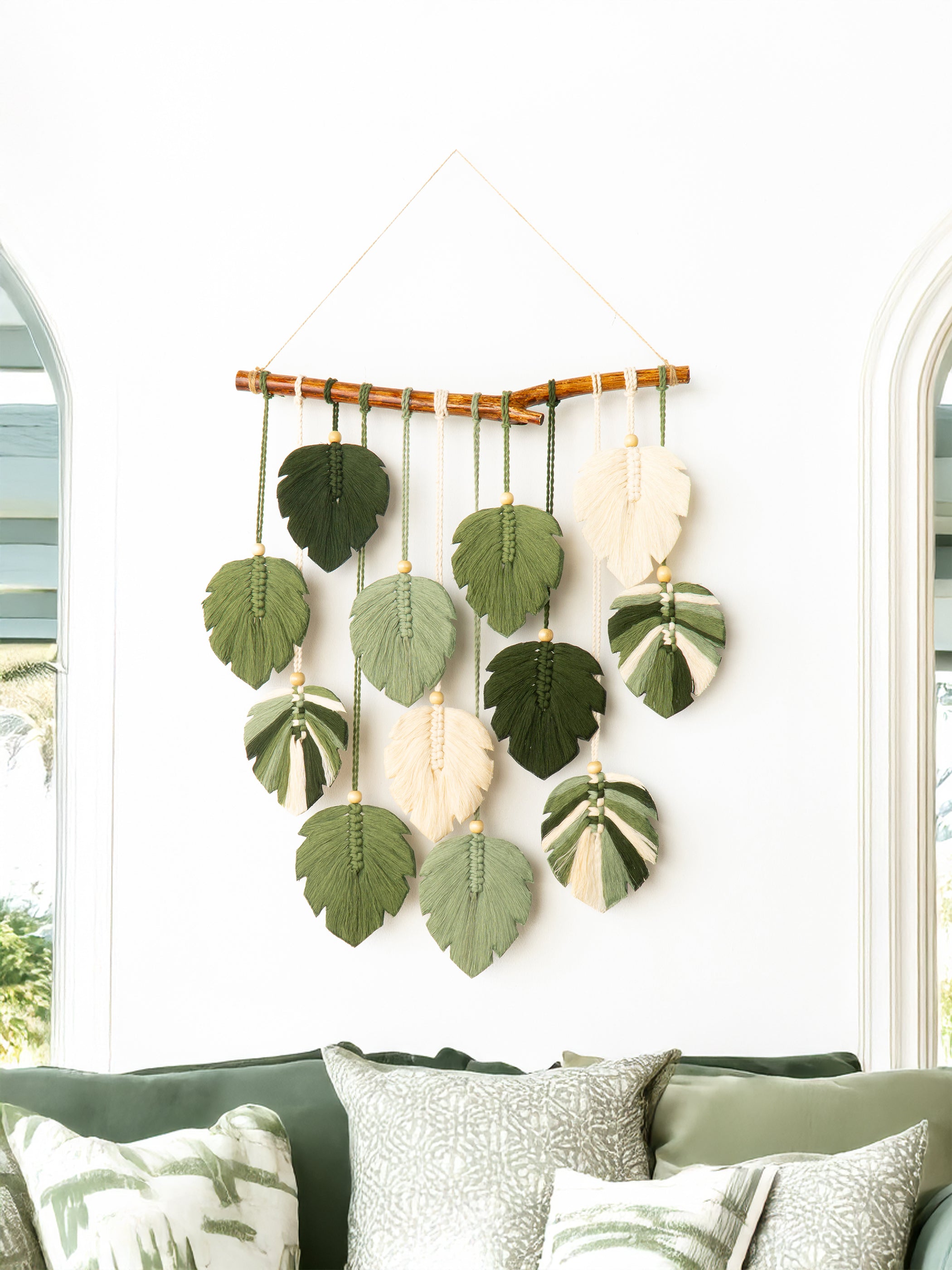 Decorative wall hanging with leaf patterns on a white wall.