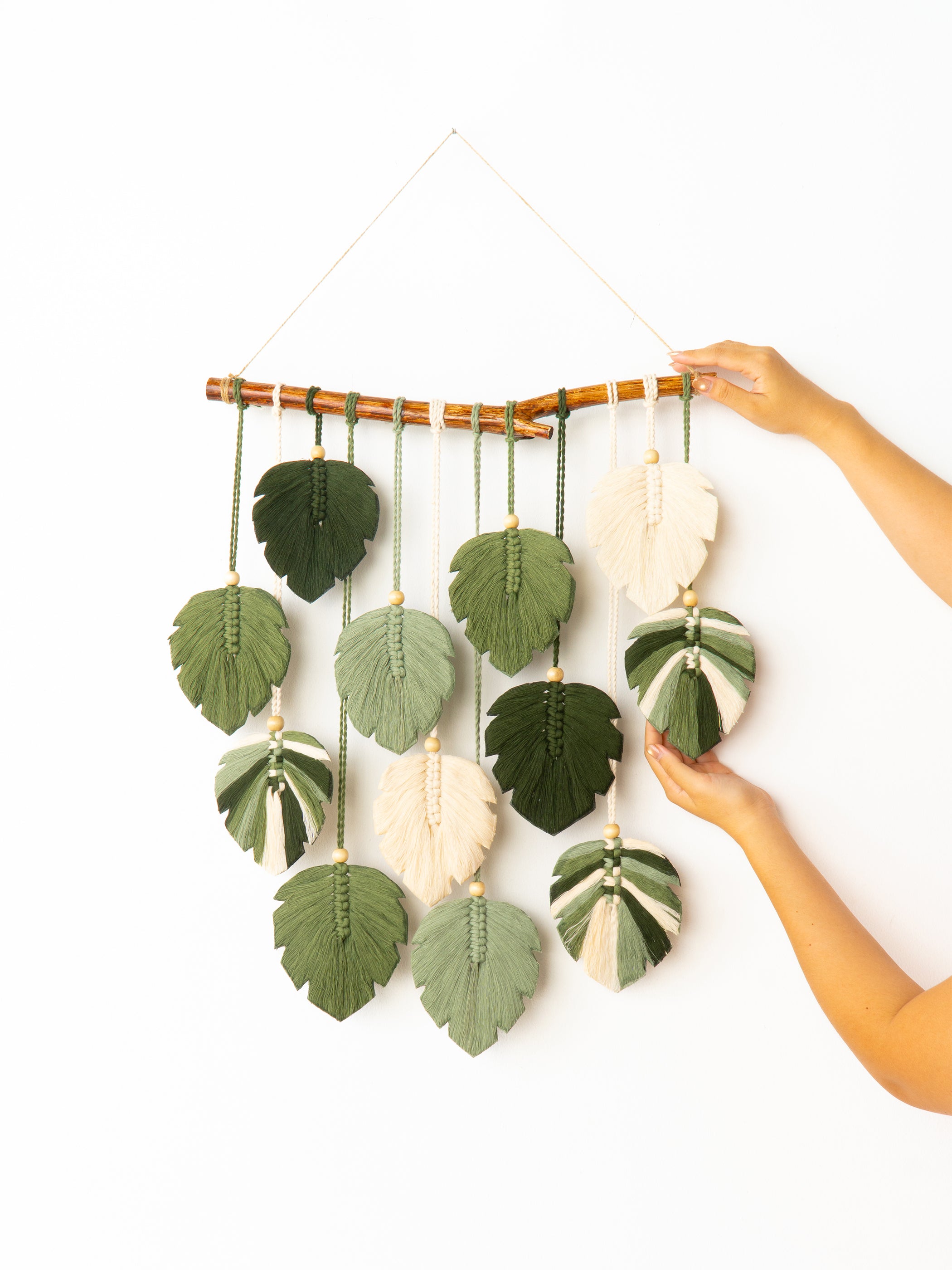 Decorative wall hanging with leaf-shaped ornaments on a white background