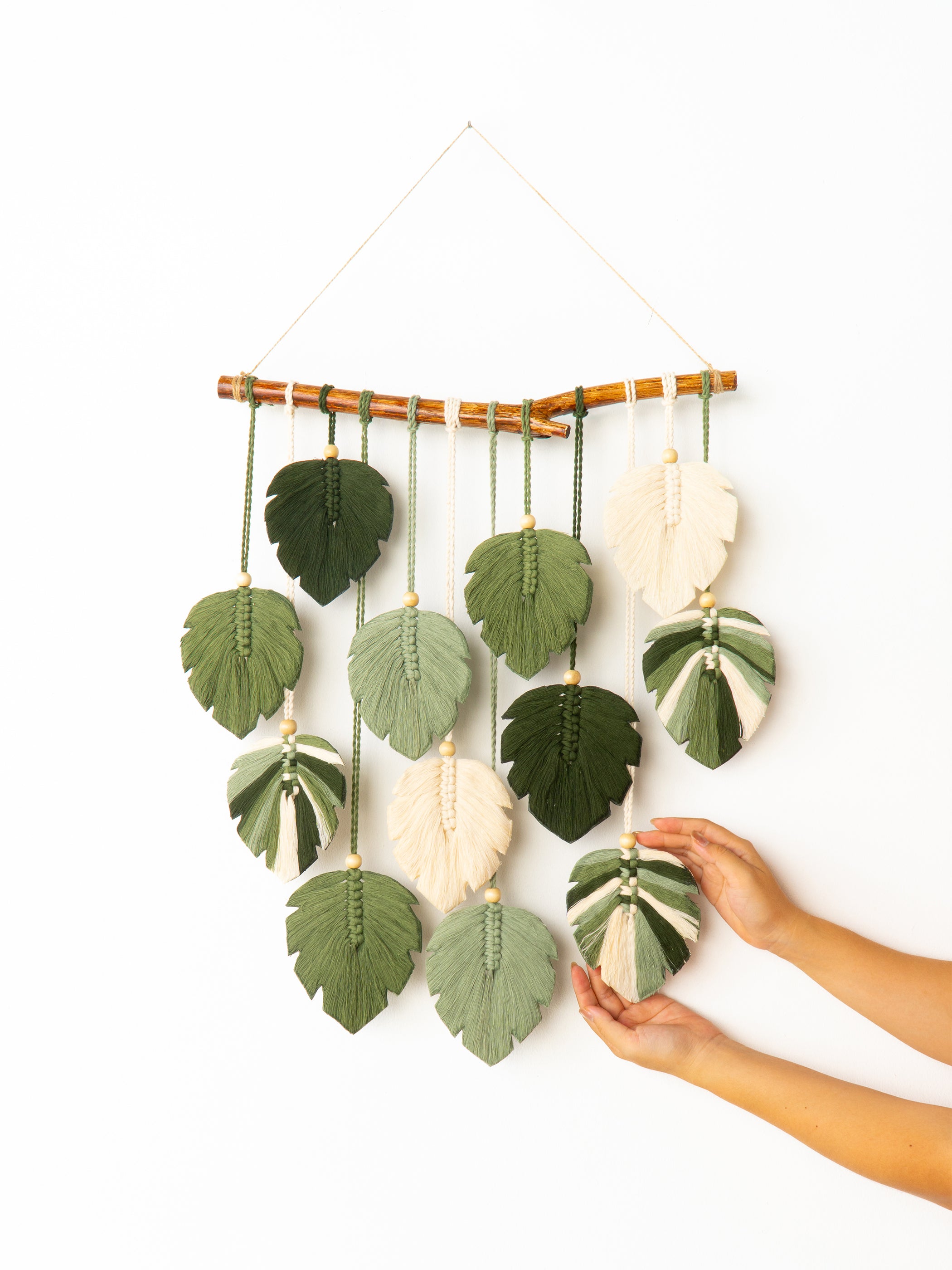 Decorative wall hanging with leaf-shaped ornaments on a white background