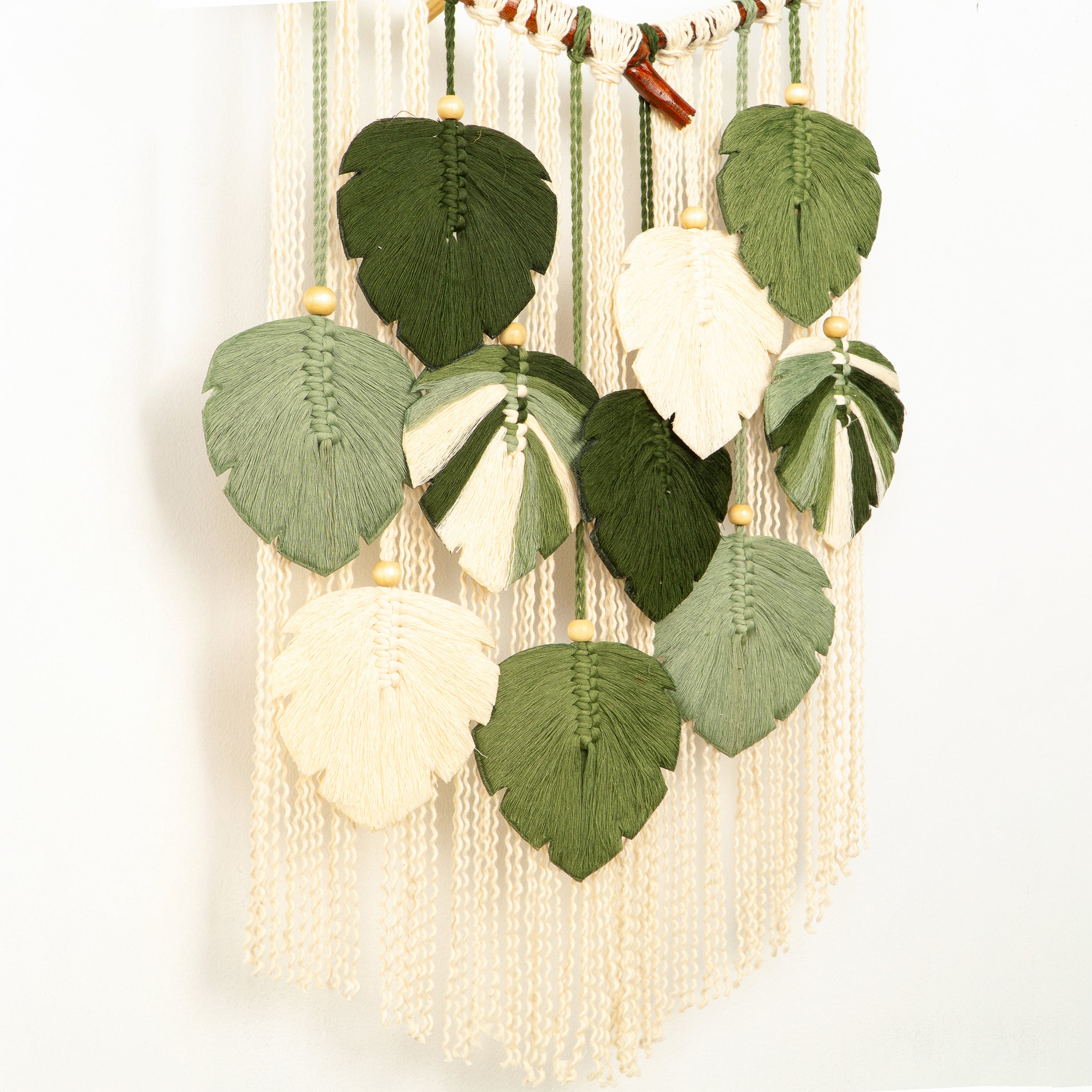 Decorative wall hanging with leaf-shaped beads on a white background