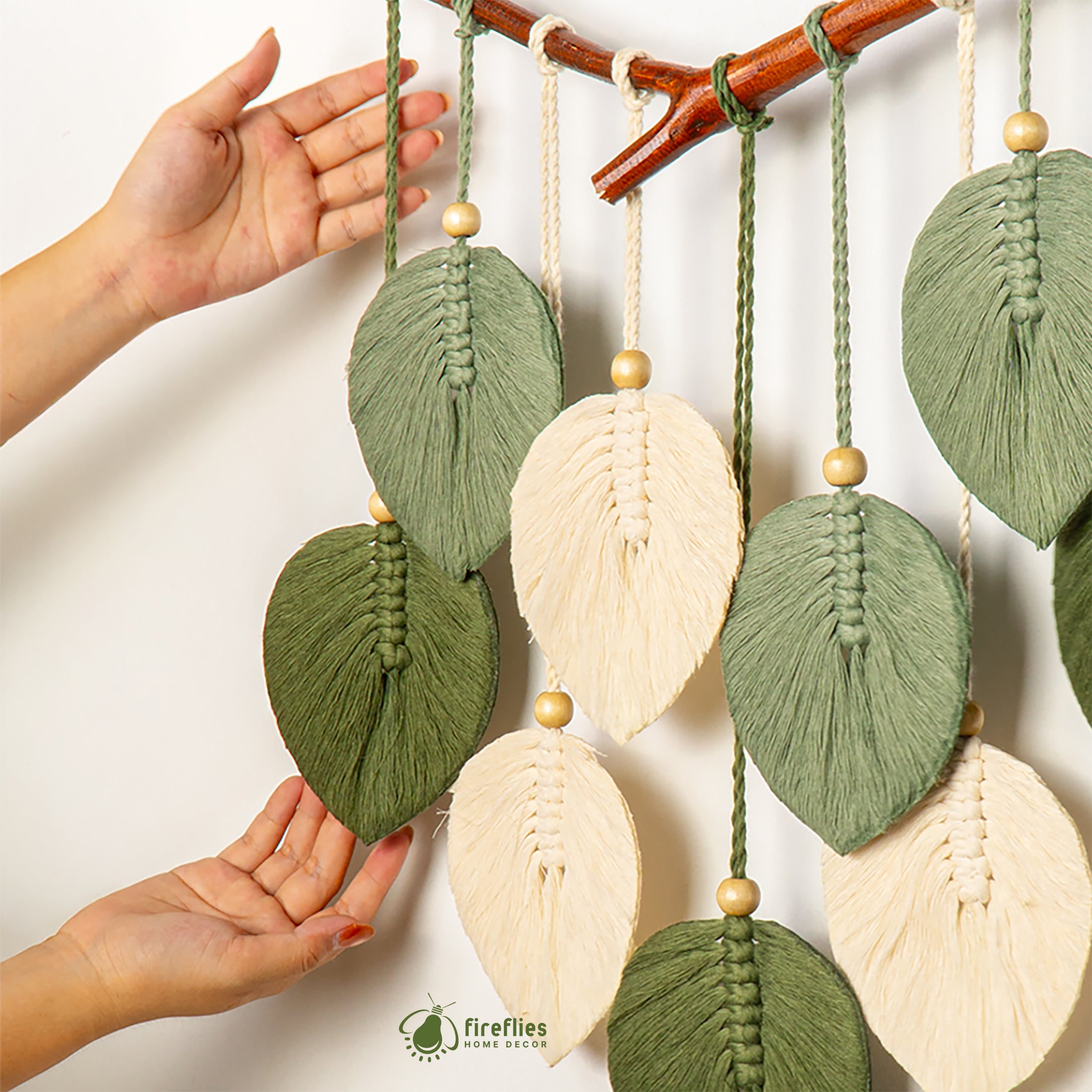 Handmade leaf-shaped decorations hanging from a branch with 'Fireflies Home' branding.