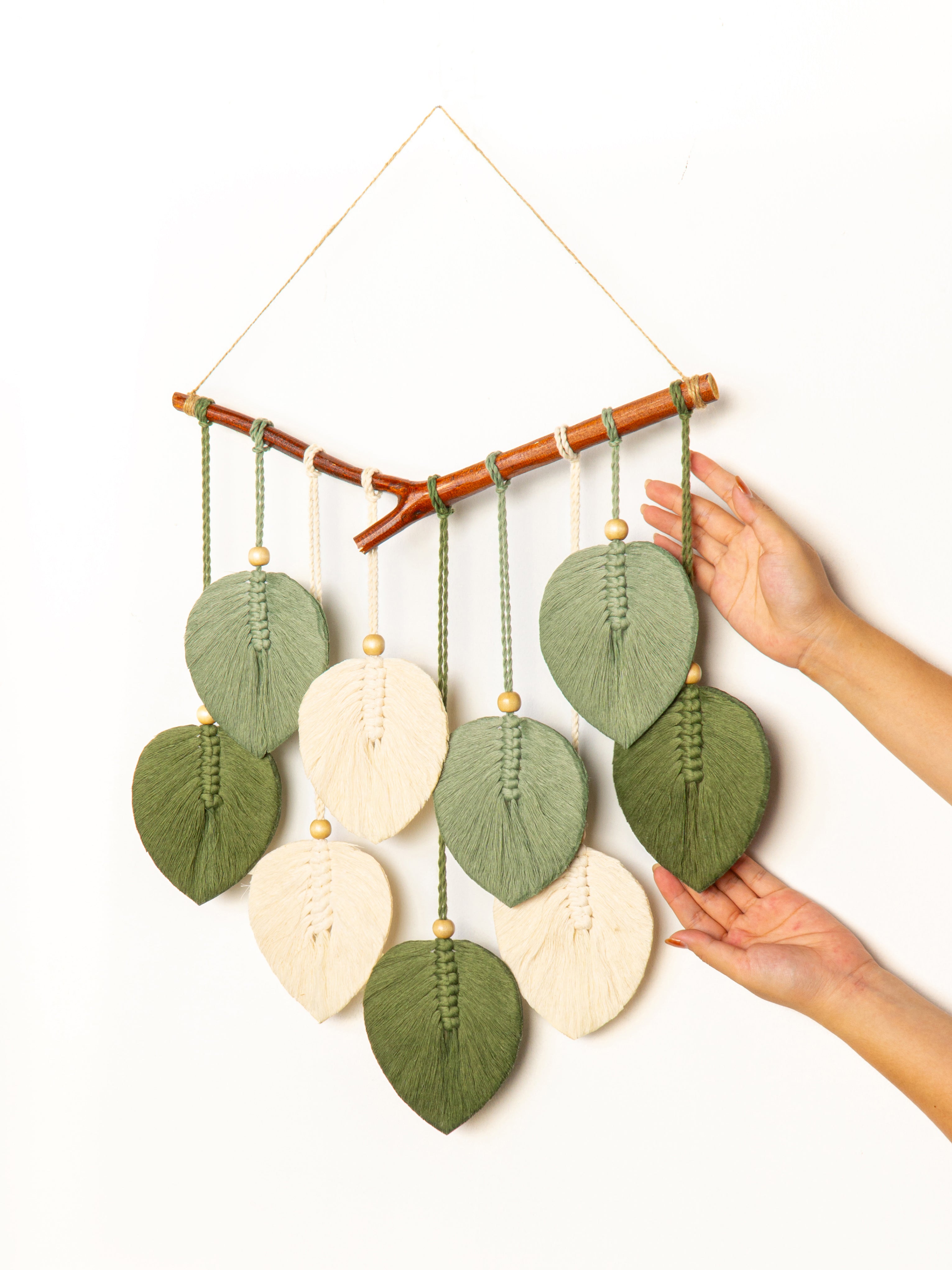 Decorative wall hanging with leaf-shaped ornaments on a white background