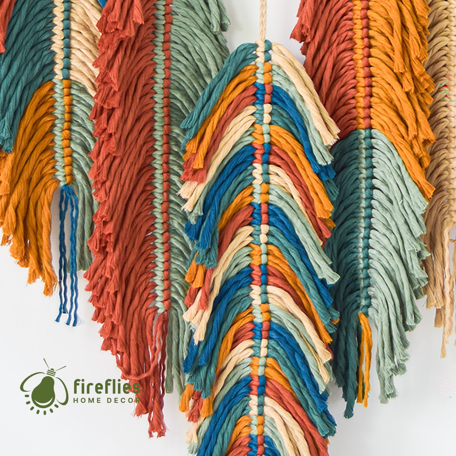 Colorful macrame wall hanging with 'Fireflies Home Decor' logo.