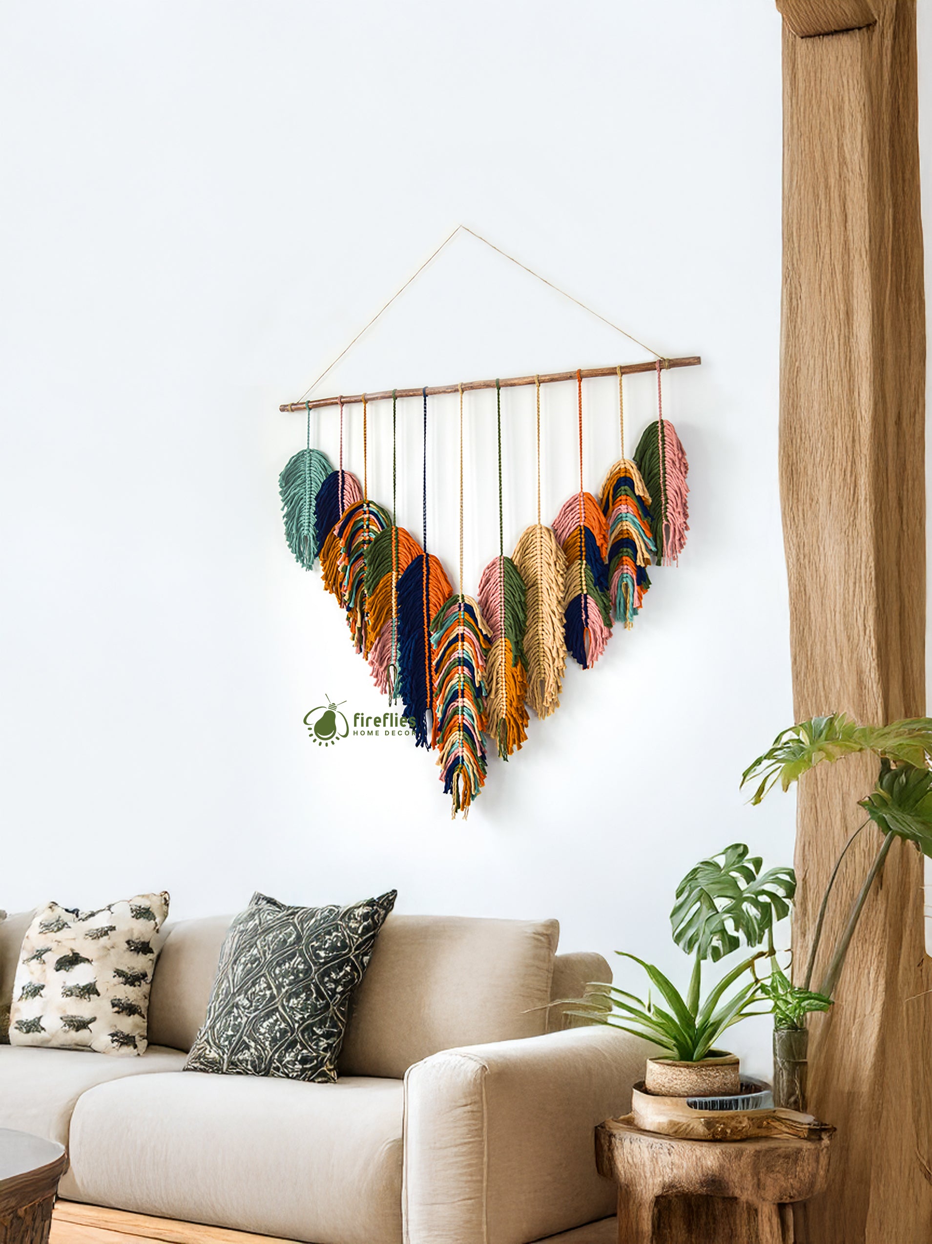 Colorful feather wall hanging above a beige sofa in a living room.