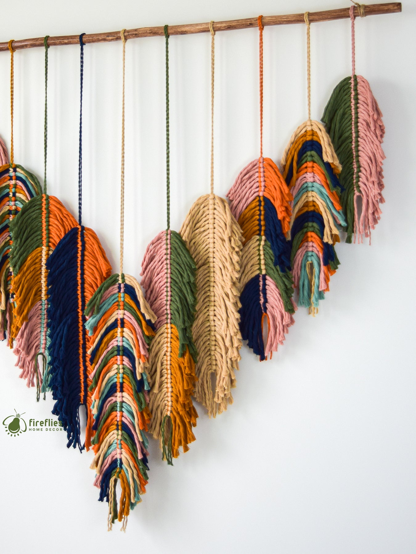Colorful macrame wall hanging on a white background