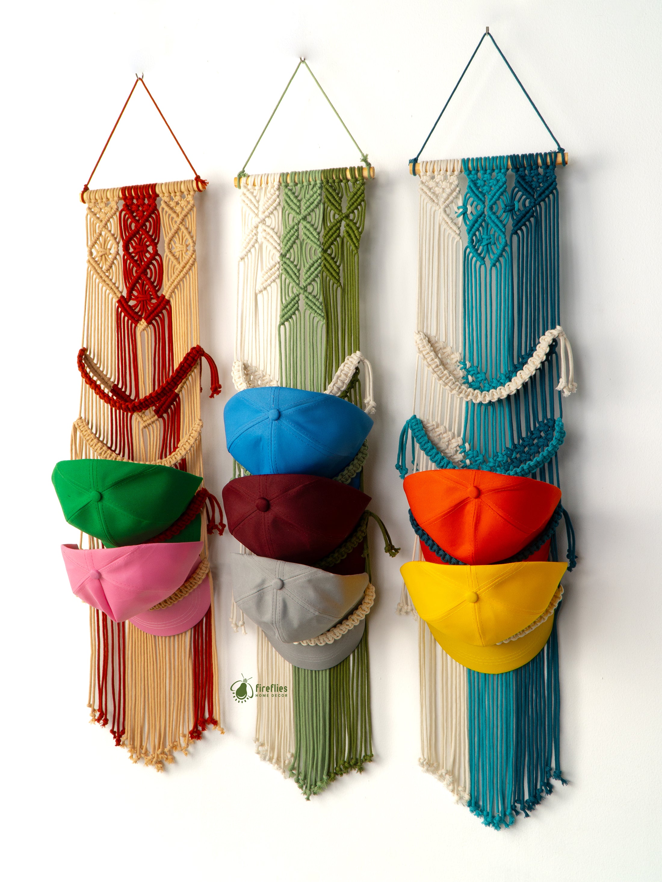 Colorful macrame wall hanging with hats on a white background