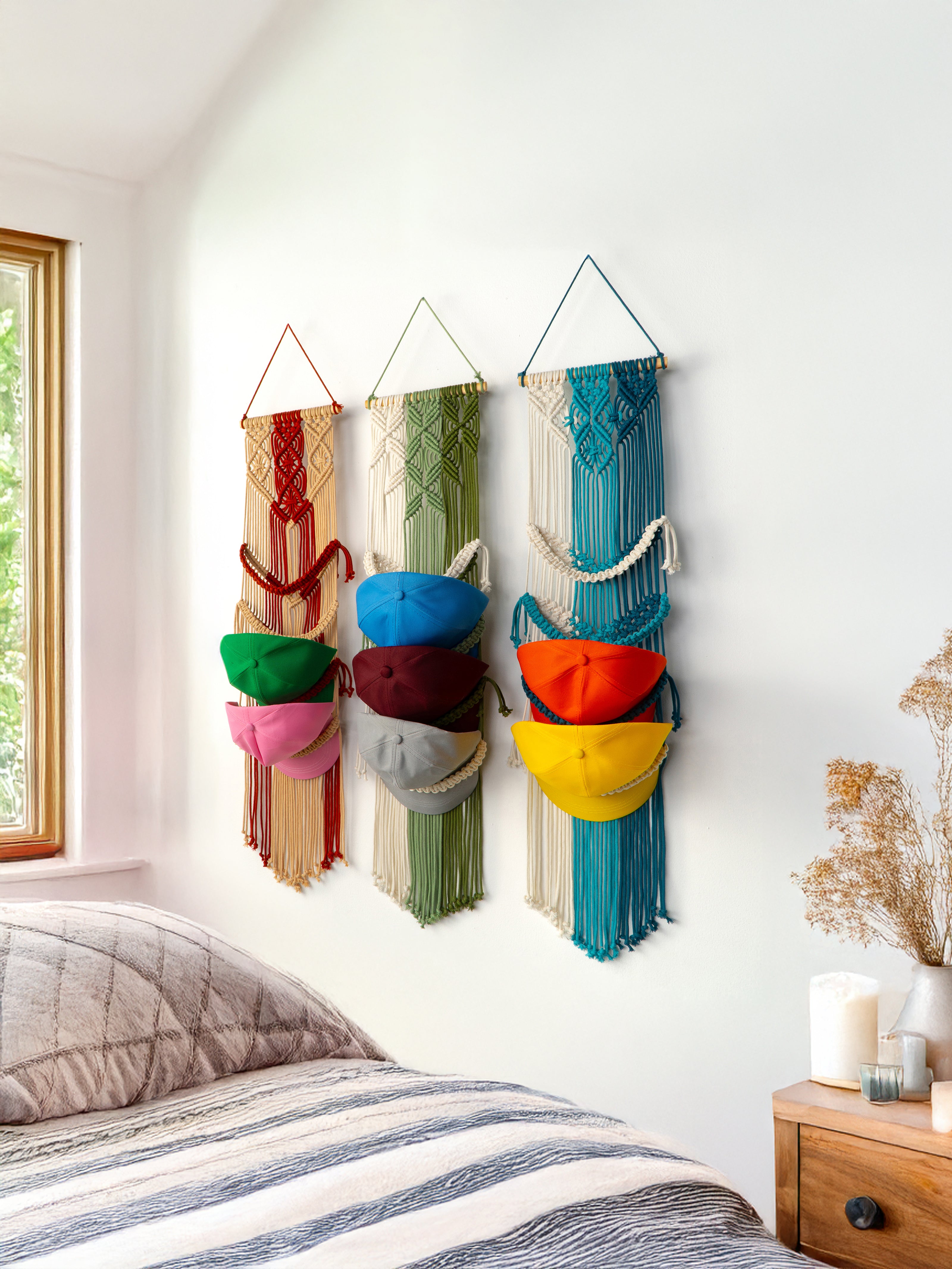 Colorful wall hangings with hats displayed on a bedroom wall.