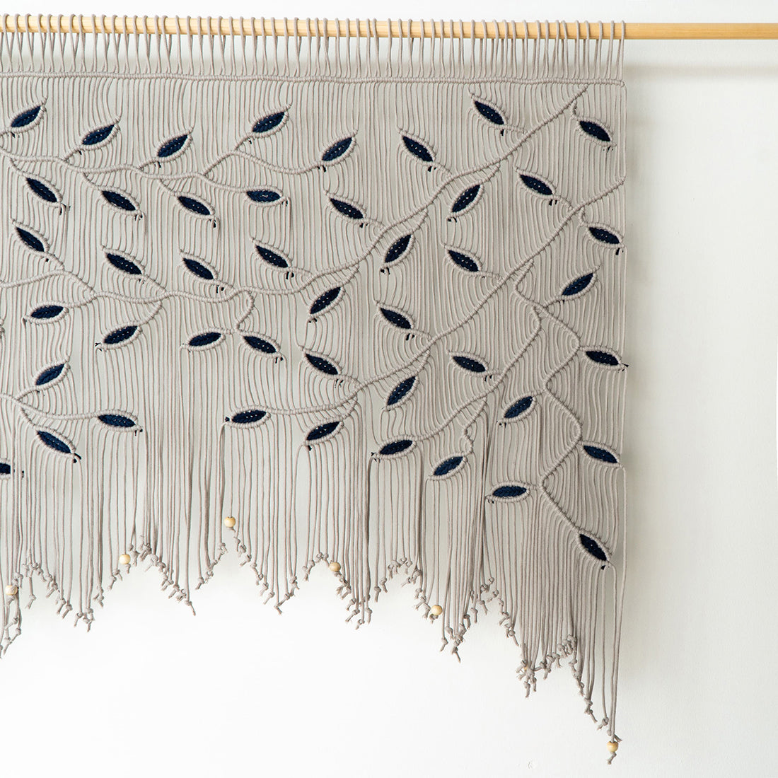 Modern boho macrame headboard in taupe and navy, perfect for over-the-bed decor in a master suite.
