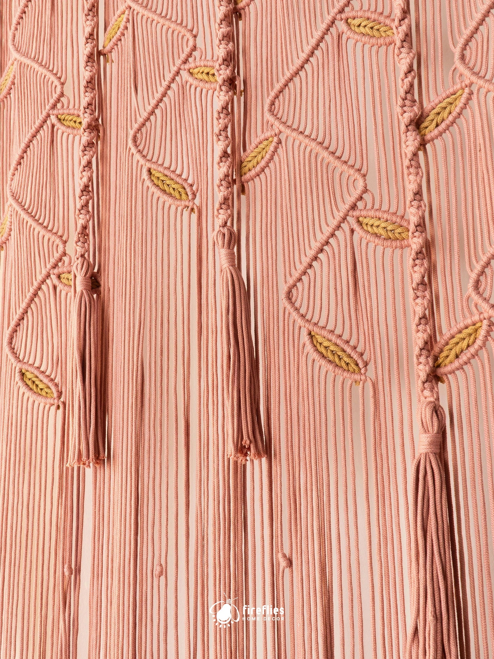 A close-up of a pink pleated fabric with vertical stitched lines, braided tassel details, and small yellow embroidered leaf accents. A small 'triplef' logo watermark is visible at the bottom center.
