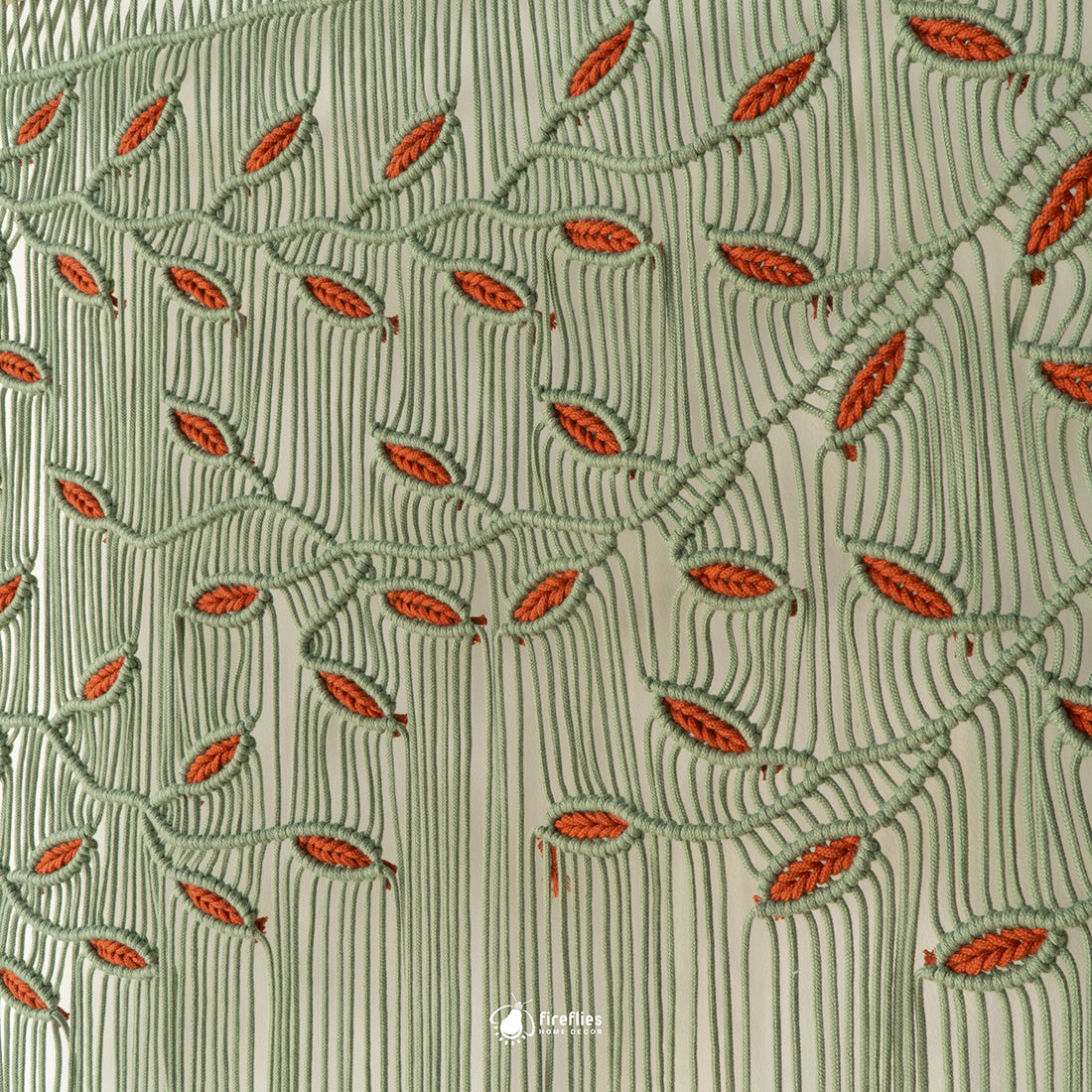 Large sage green macrame wall hanging with terracotta orange hand-knotted leaf accents and a botanical vine design.