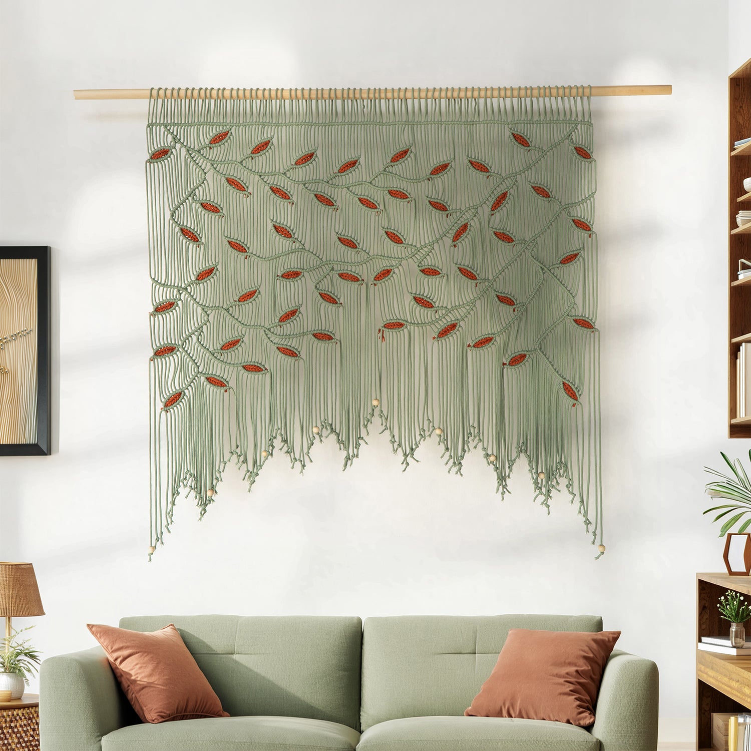 Decorative wall hanging with leaf pattern above a green sofa in a living room.