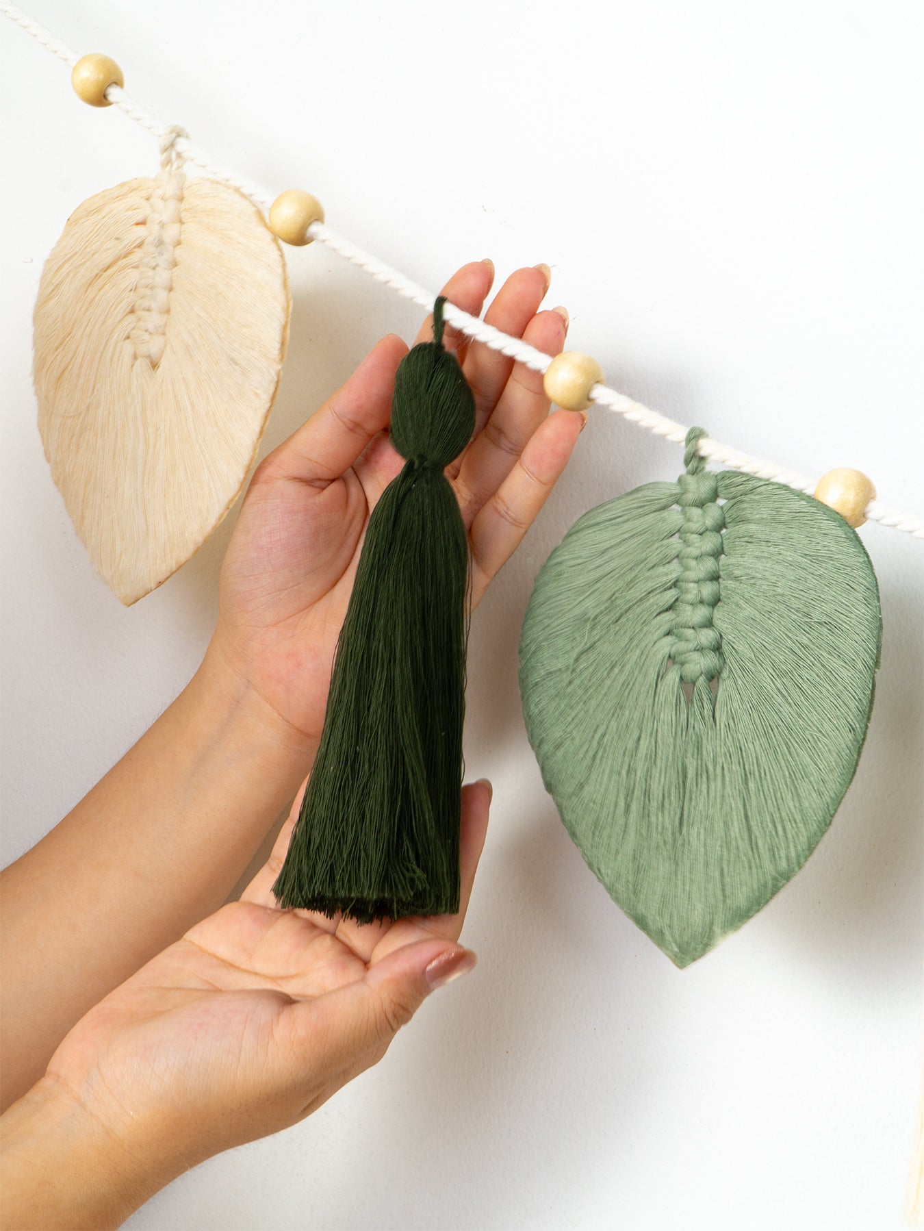 Two wall-mounted art pieces with wooden and black circular designs on a white background.