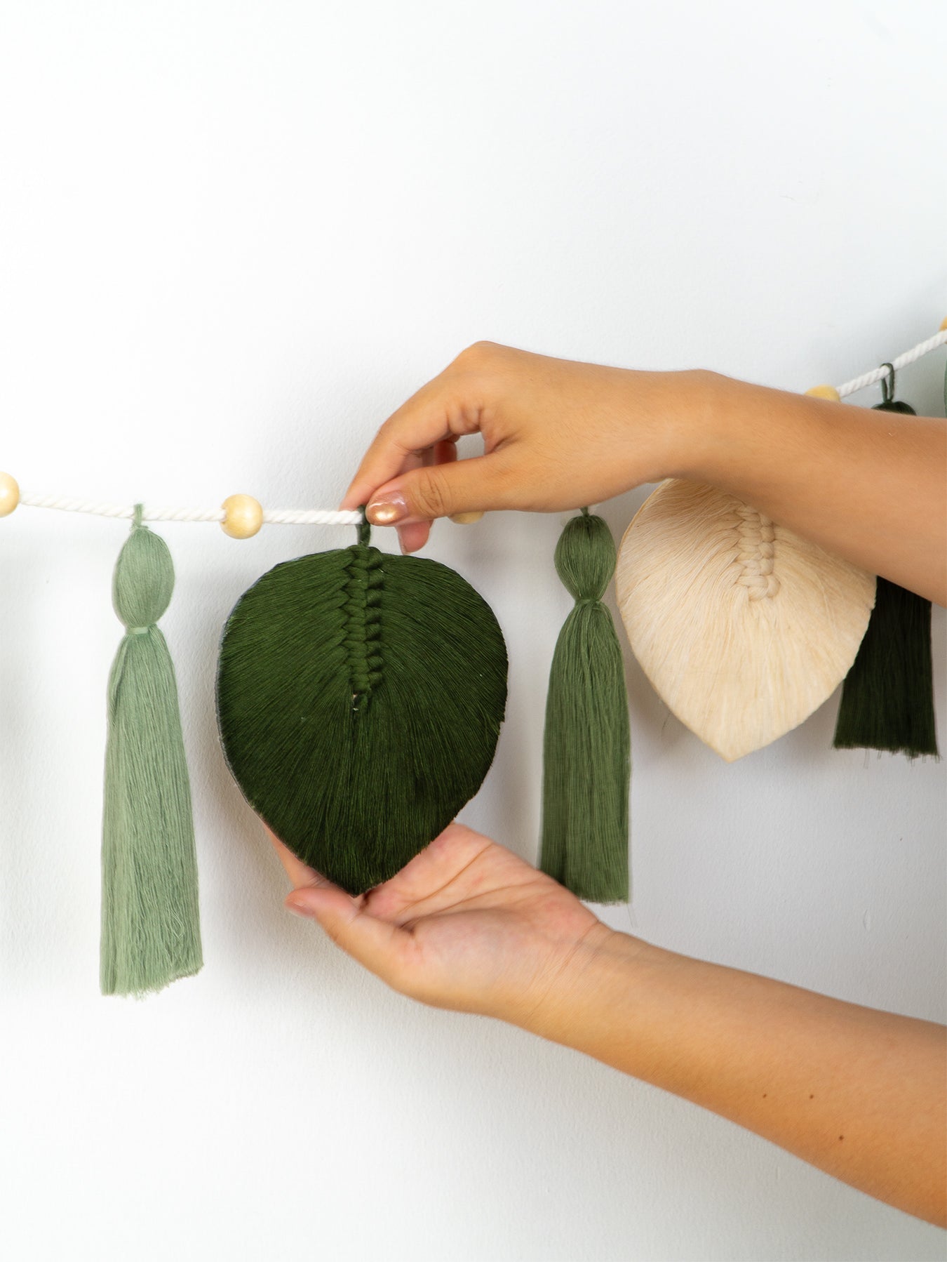 Two wall-mounted art pieces with wooden and fabric elements on a white background