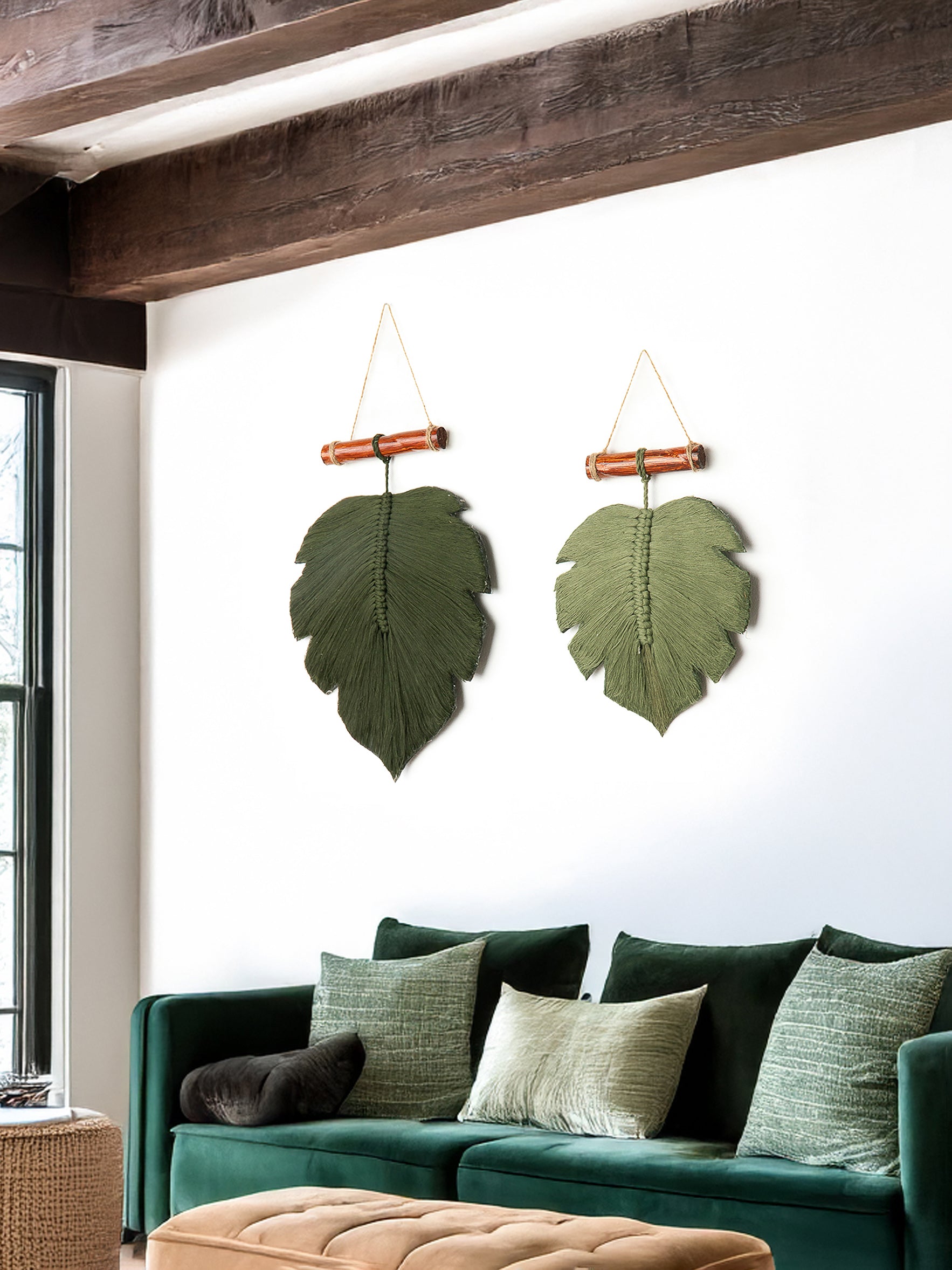 Green leaf-shaped wall hangings above a green sofa with decorative pillows.