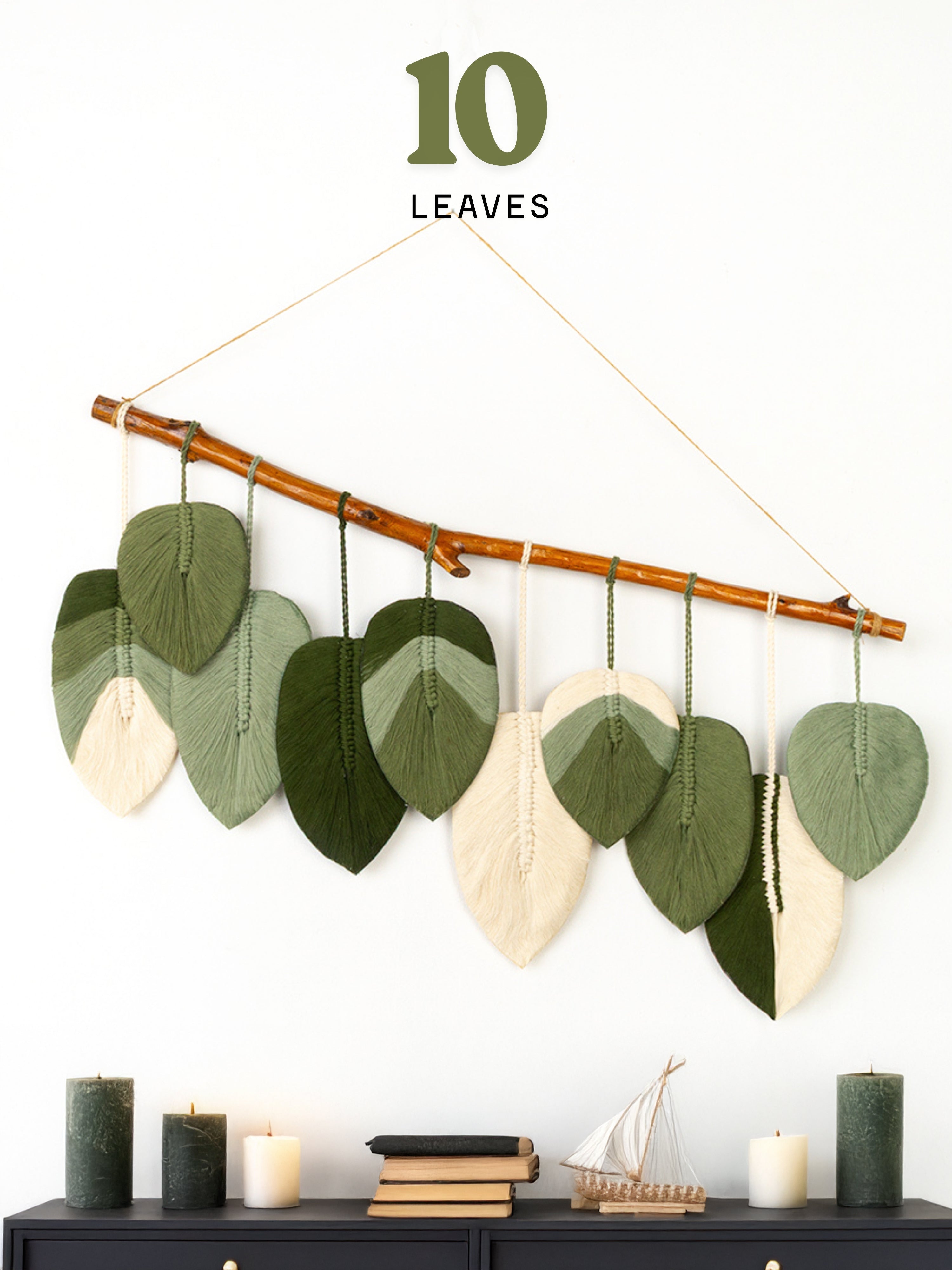 Decorative wall hanging with leaves on a branch against a white background