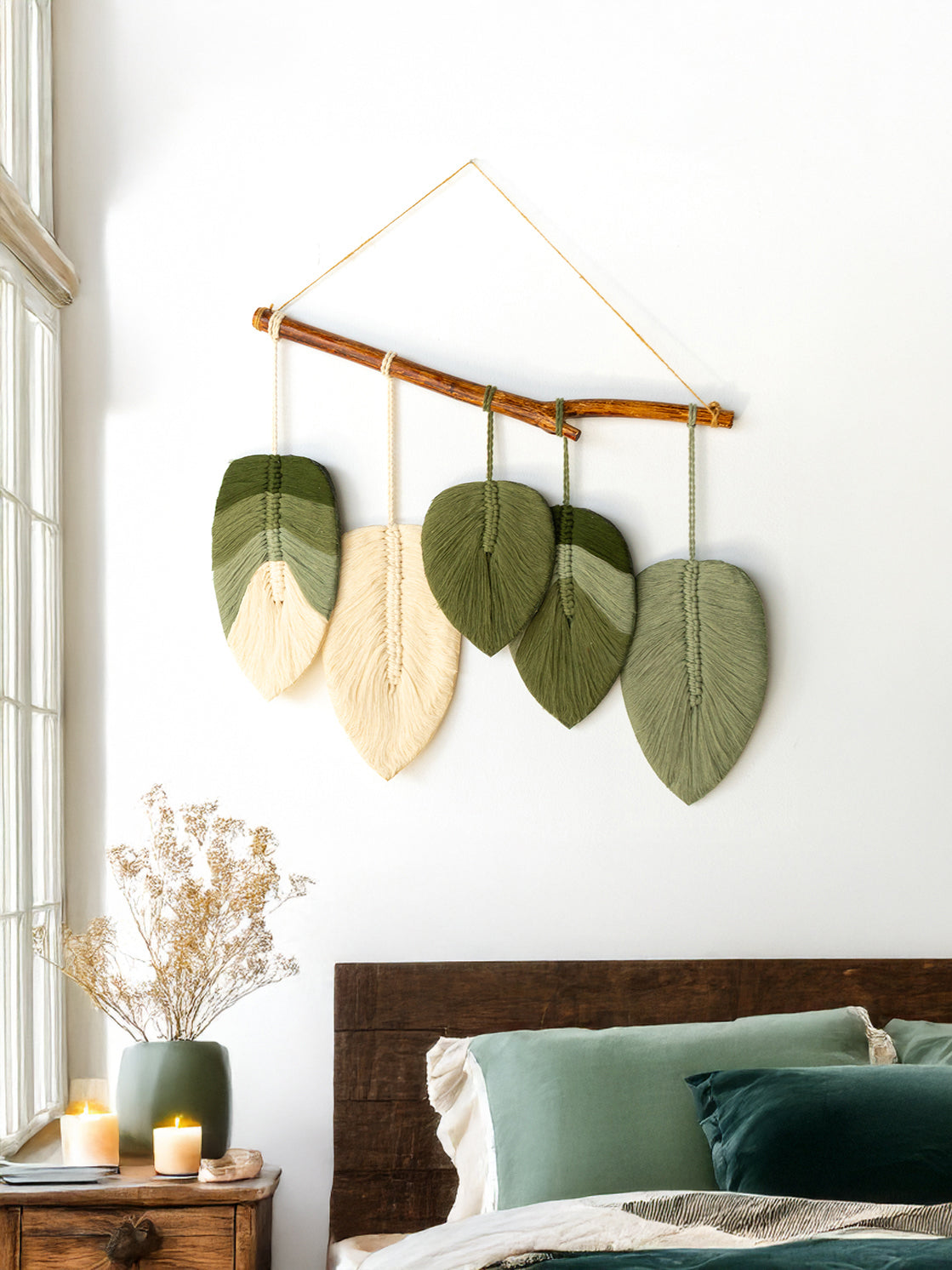 Decorative wall hanging with leaf-shaped leaves in a bedroom setting.