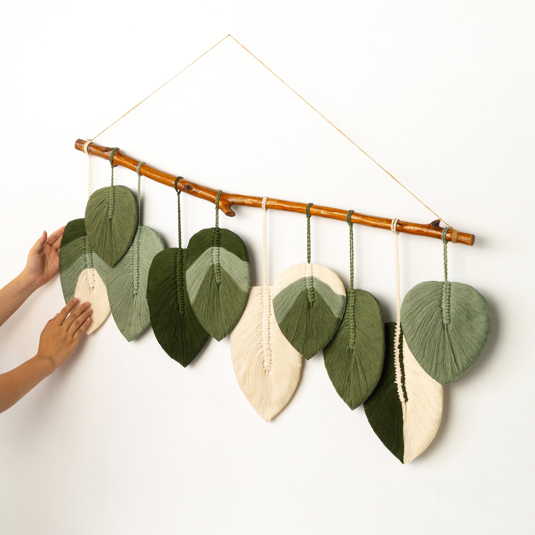 Decorative wall hanging with leaf-shaped fabric pieces on a white background