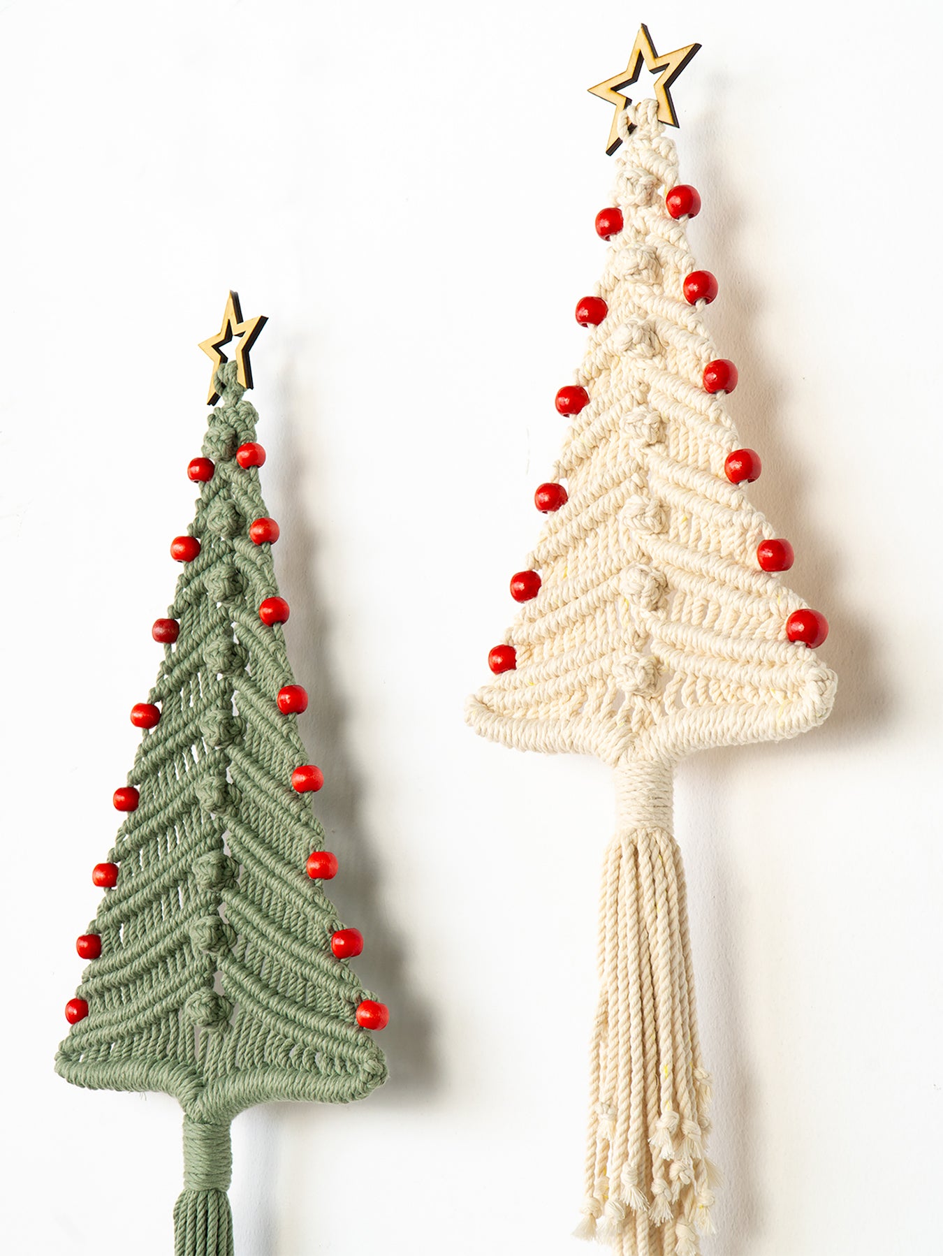 Two macrame Christmas tree decorations, one green and one beige, on a white background.