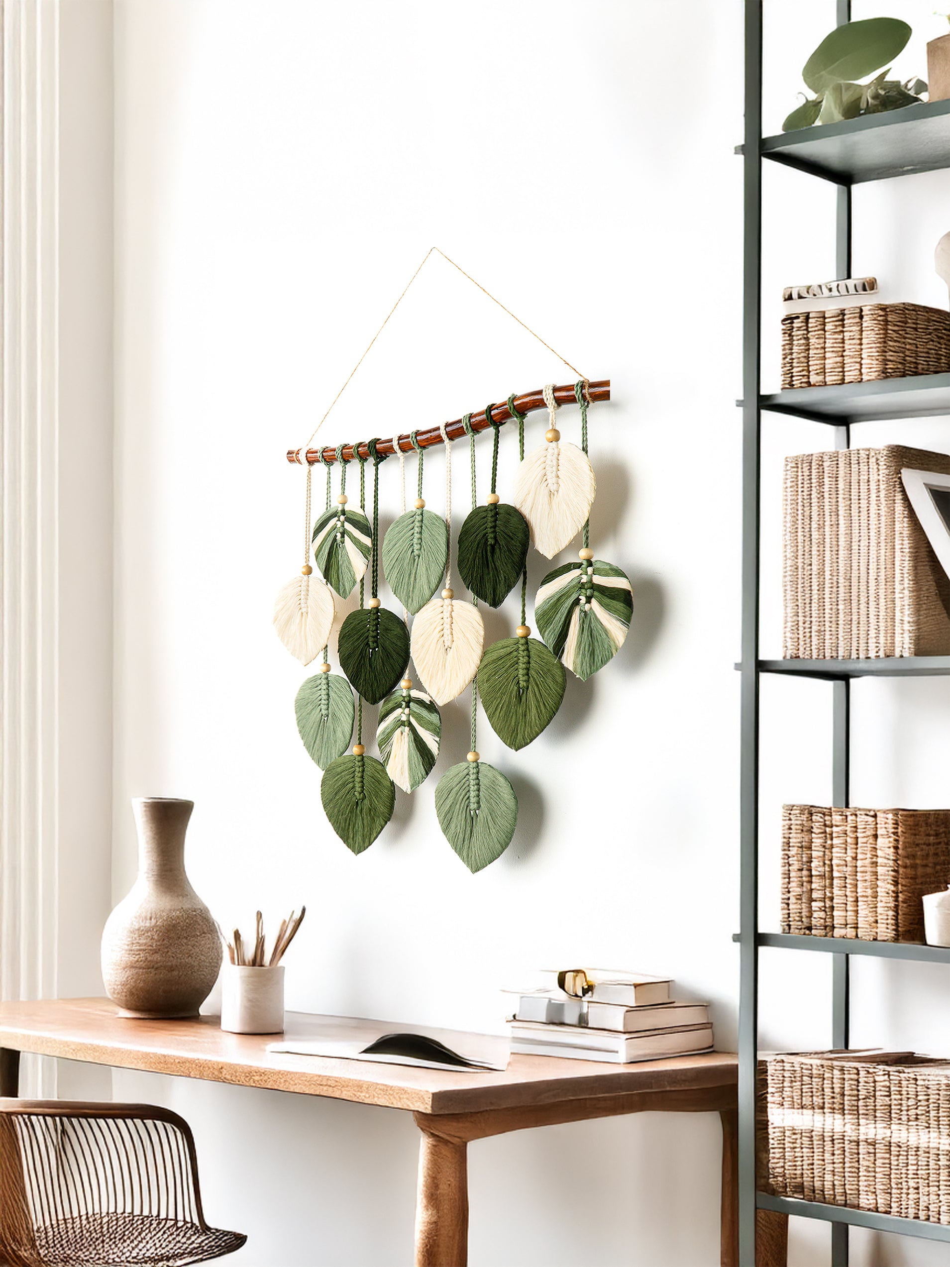 Decorative wall hanging with leaf patterns above a desk in a home office setting.