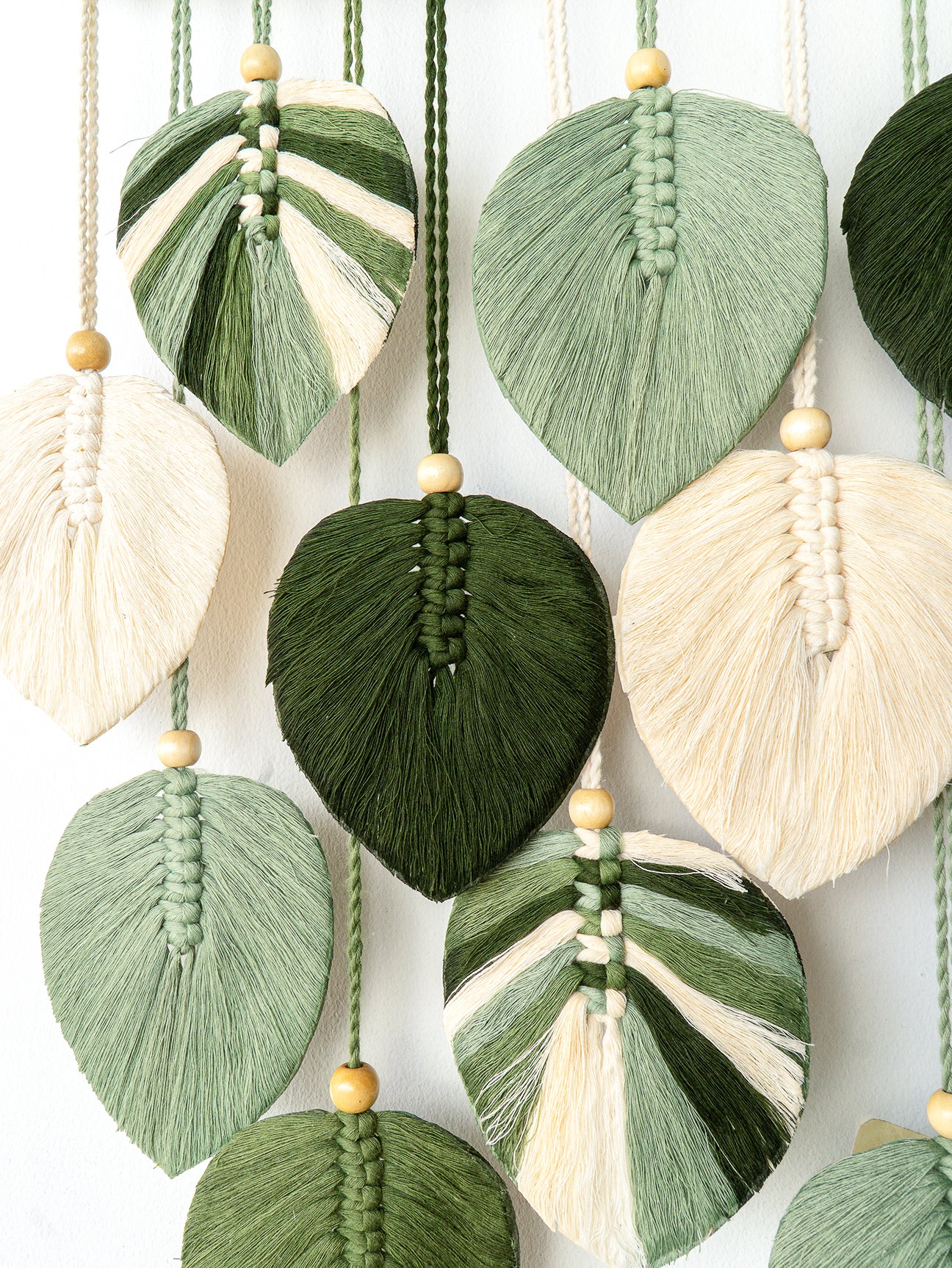 Colorful tassel decorations with a macrame pattern on a white background