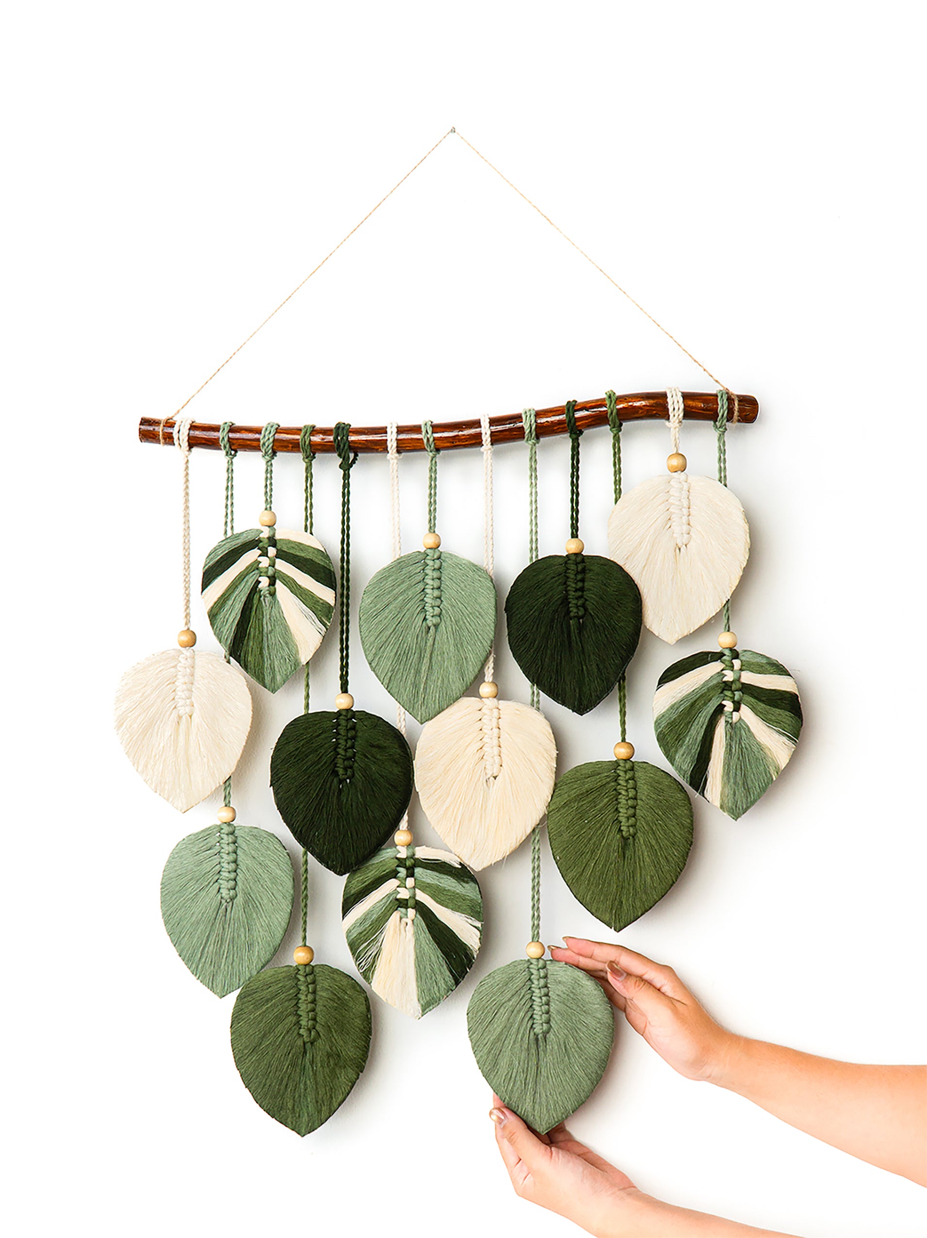 Decorative wall hanging with leaf-shaped fabric pieces on a white background